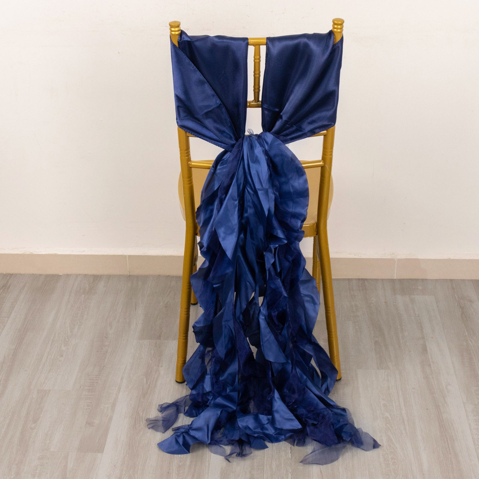 Navy blue curly chiffon satin chair sash on a gold chair.