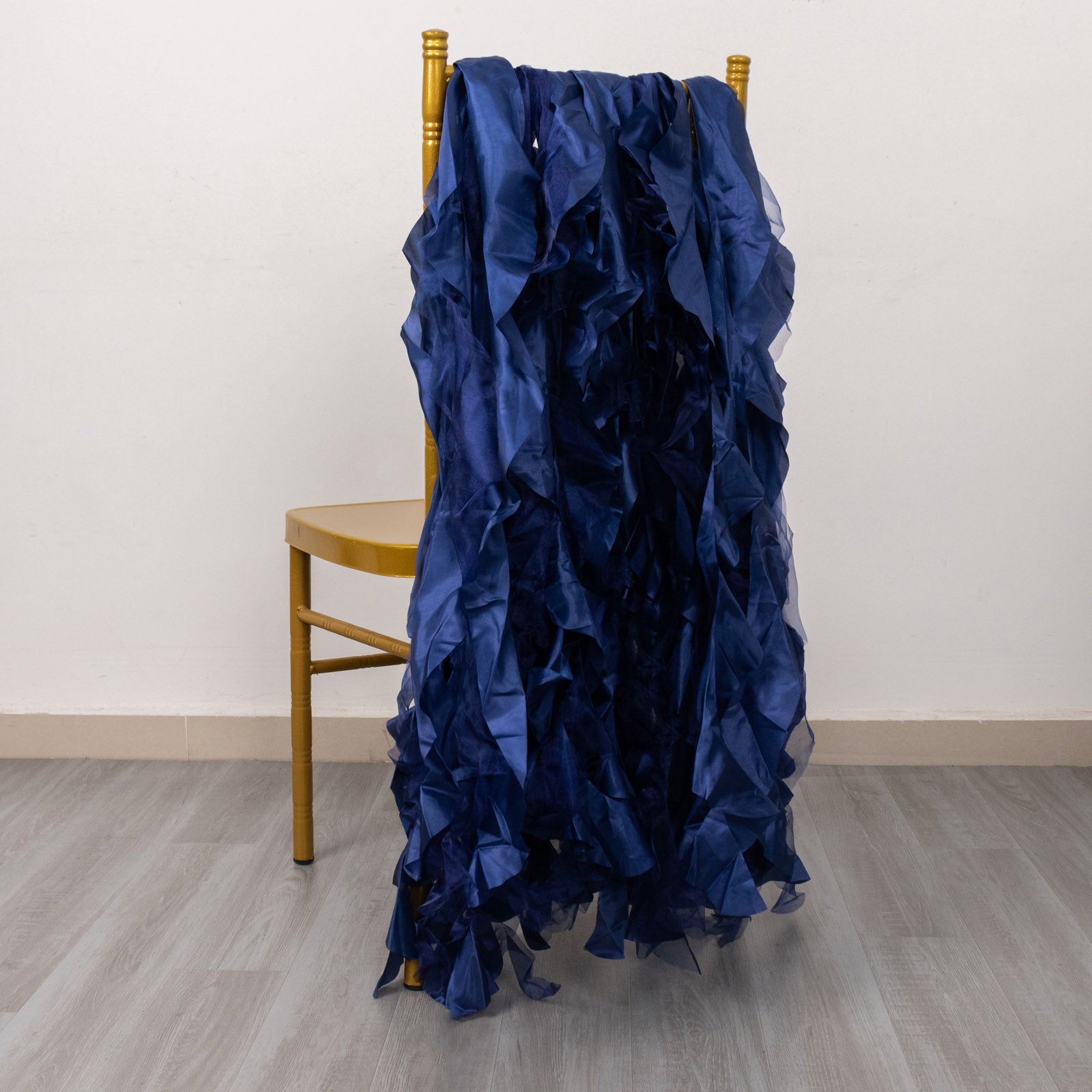 Navy blue curly chiffon satin chair sashes draped over a chair.