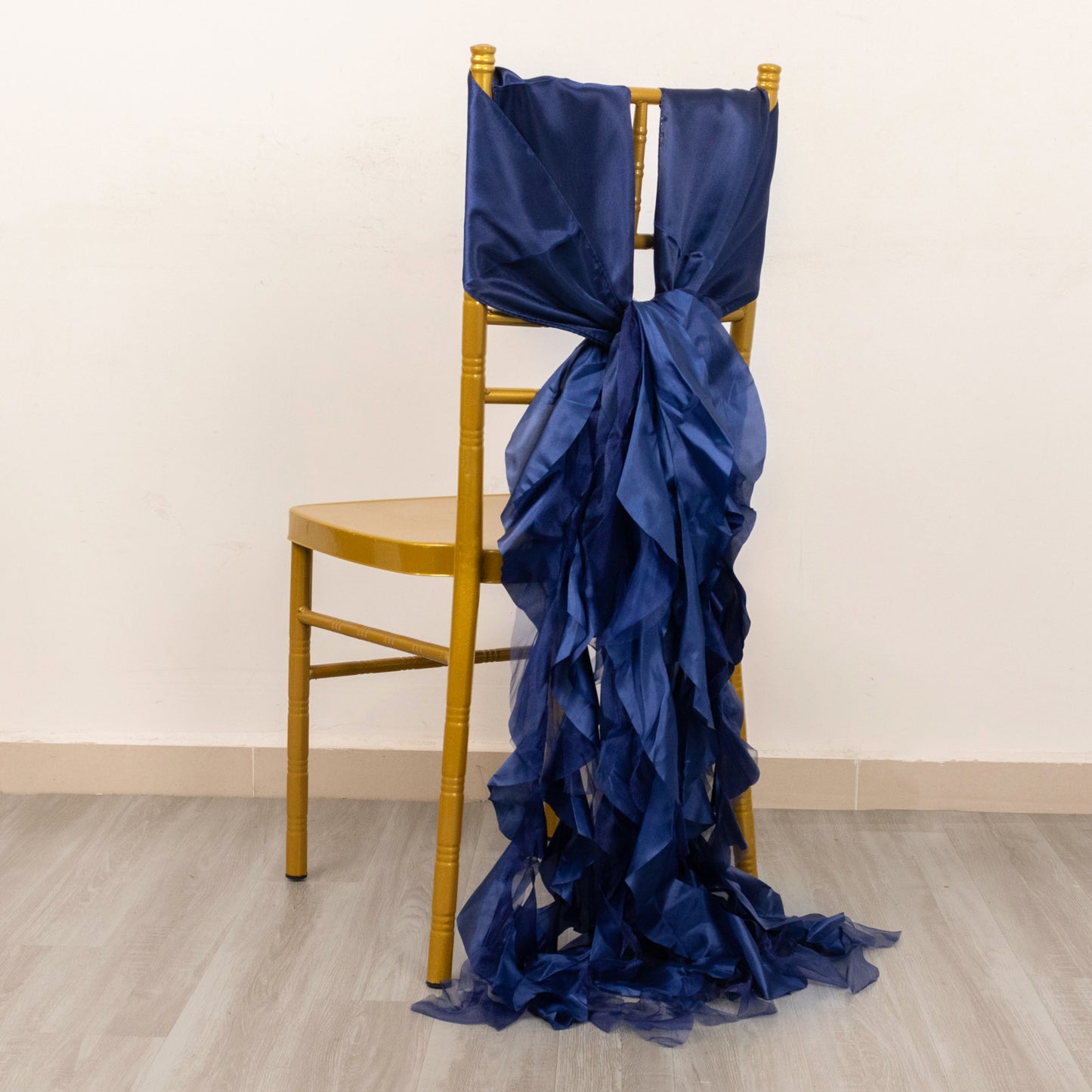 Navy blue chiffon satin chair sashes elegantly draped on a chair.
