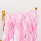 Pink chiffon satin chair sashes draped over a gold chair.