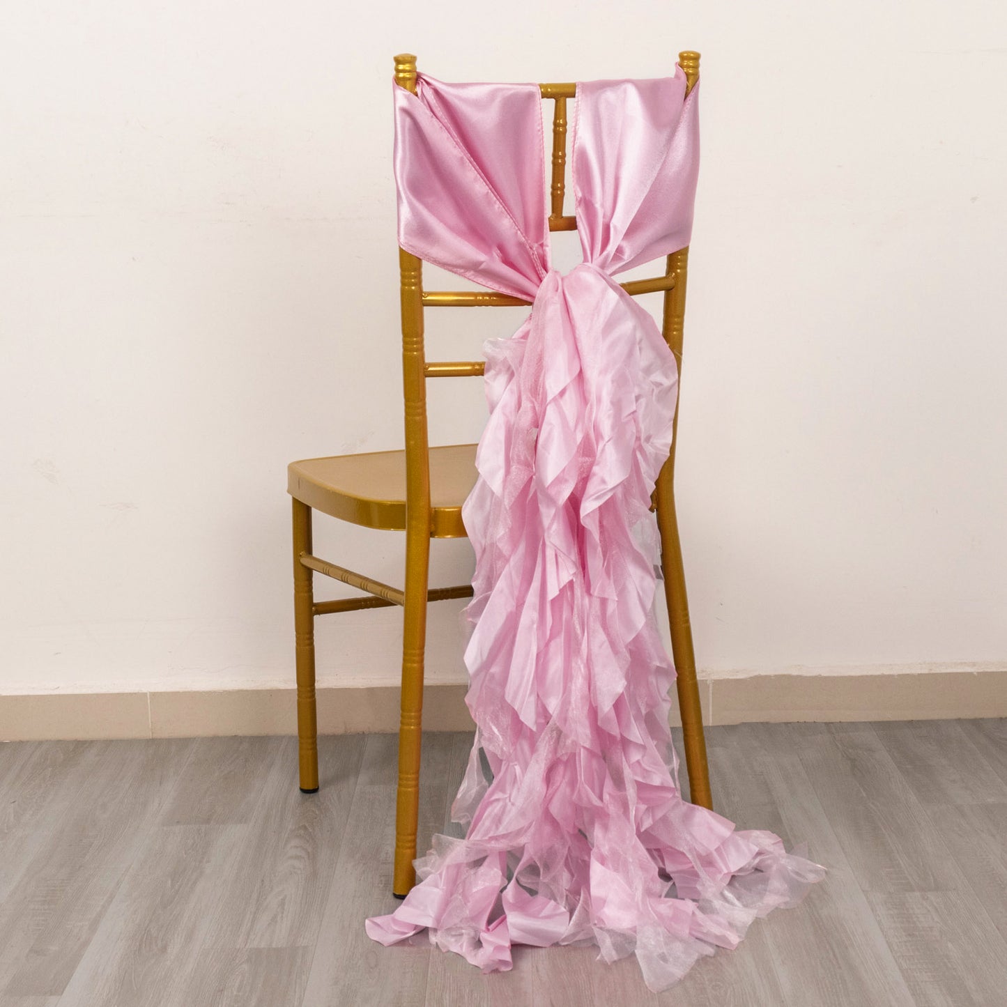Pink chiffon satin chair sash on a gold chair.