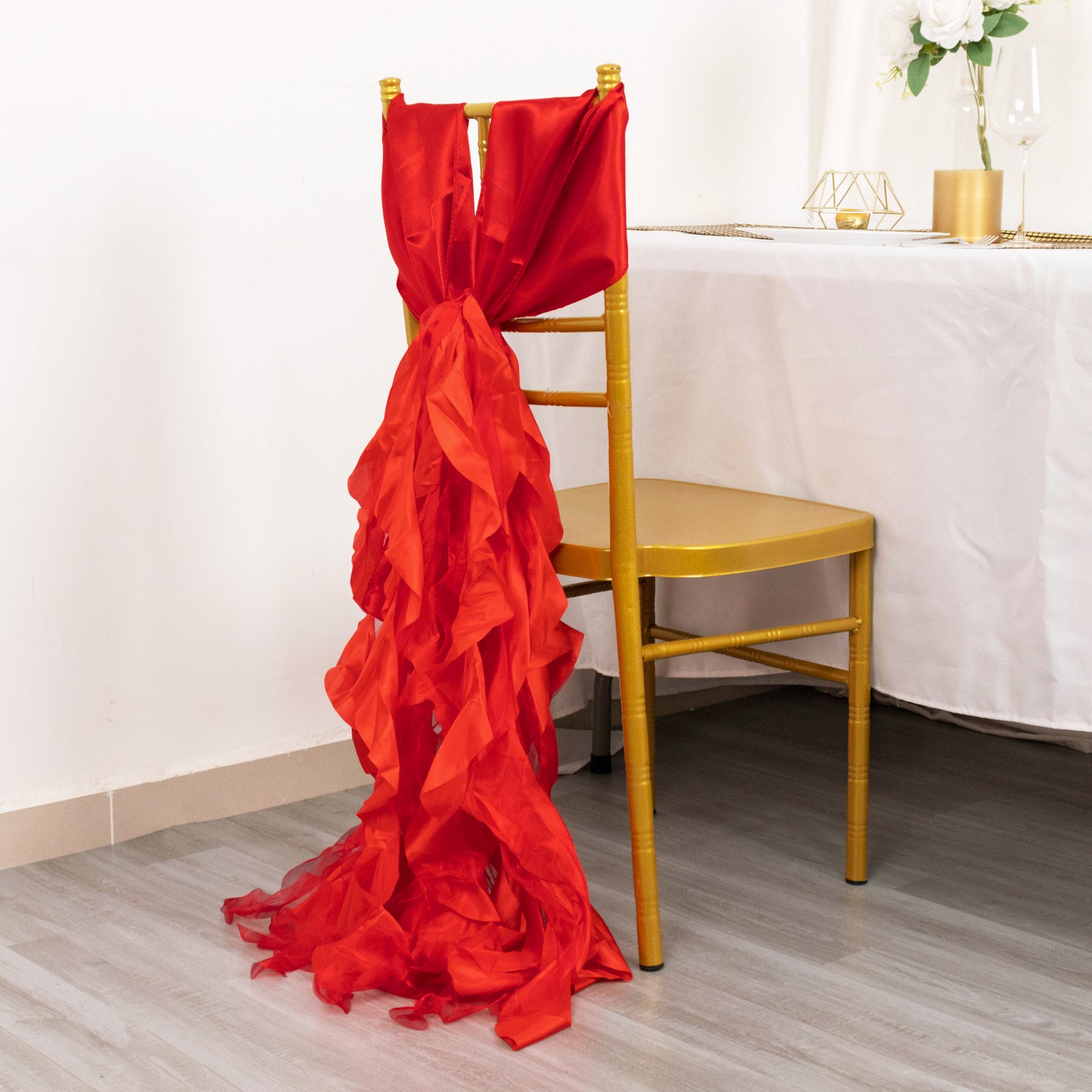 Red curly willow chiffon satin chair sash on a golden chair.