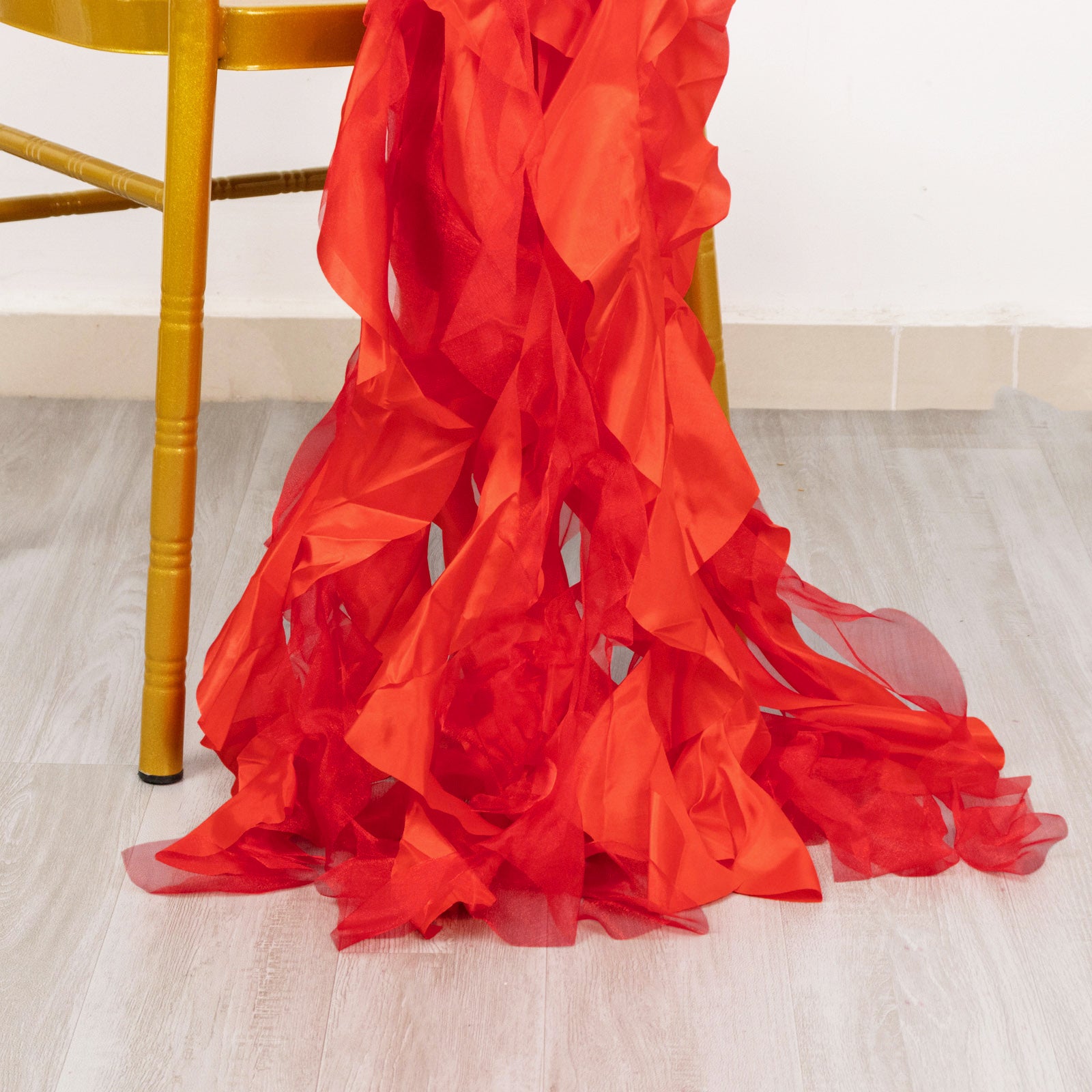 Red chiffon satin chair sashes draped on a chair.