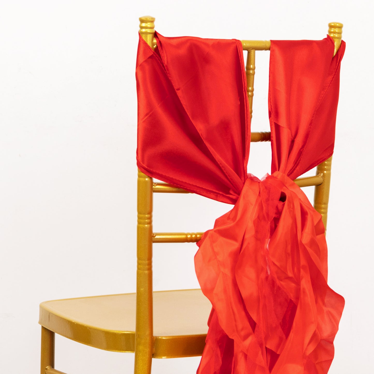 Red chiffon satin chair sashes on a gold chair.