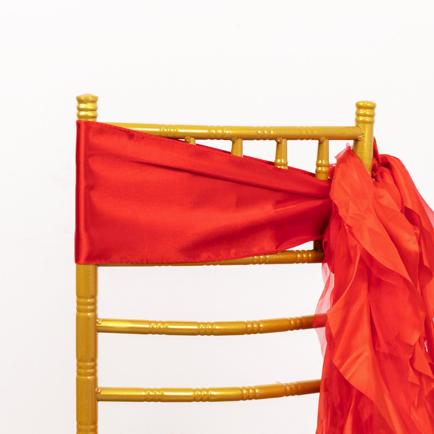 Red chiffon satin chair sash on a gold chair.