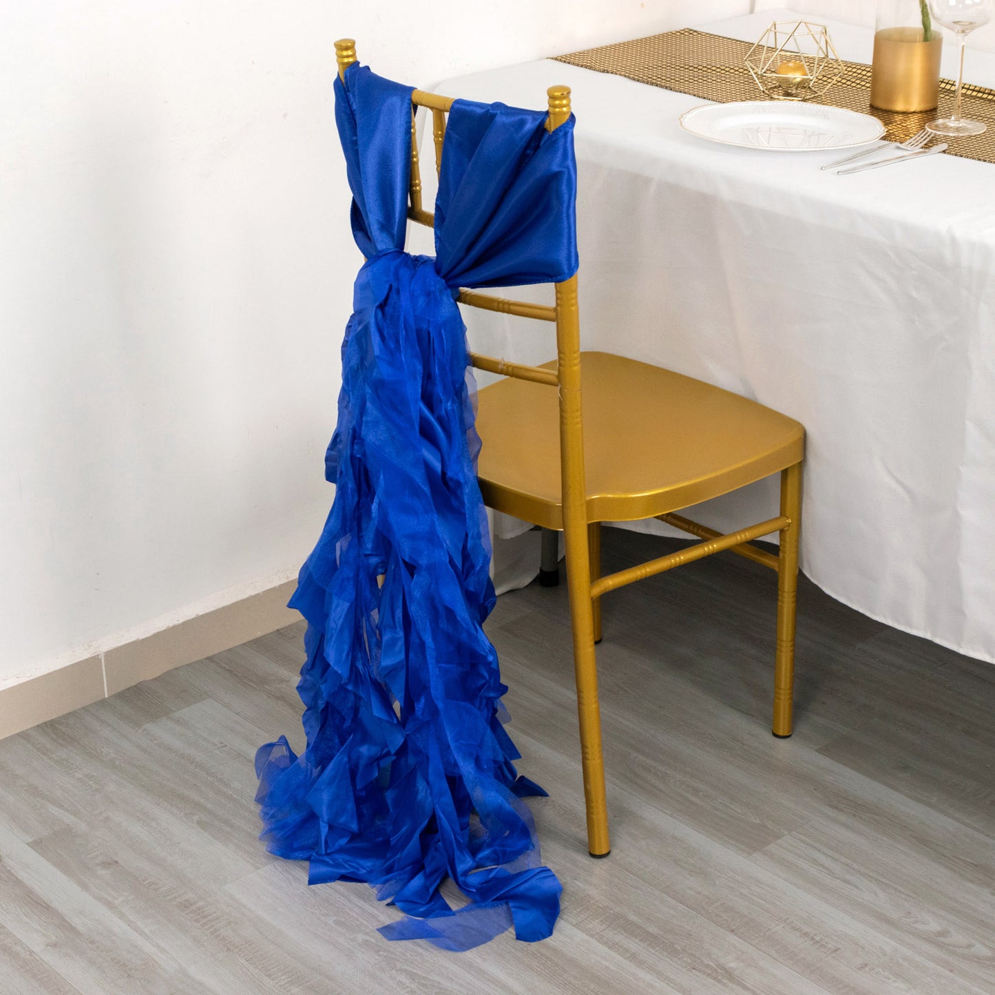 Royal blue chiffon satin chair sash draped elegantly on a gold chair.