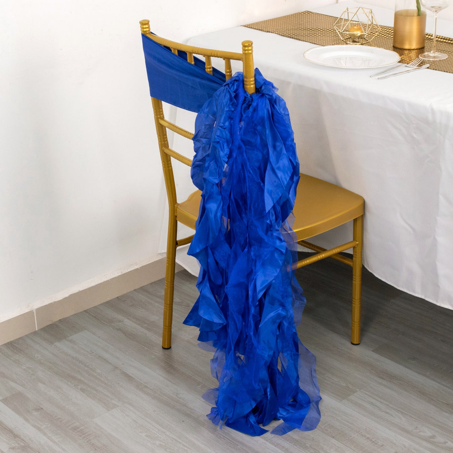 Royal blue curly willow chiffon satin chair sash on a gold chair.