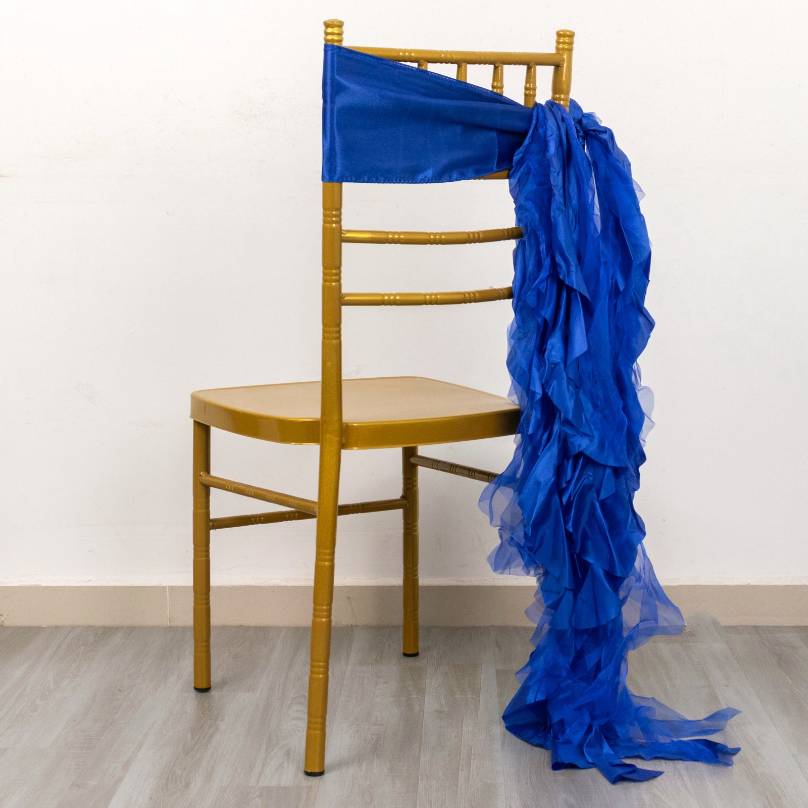 Royal blue curly willow chiffon satin chair sash on a gold chair.