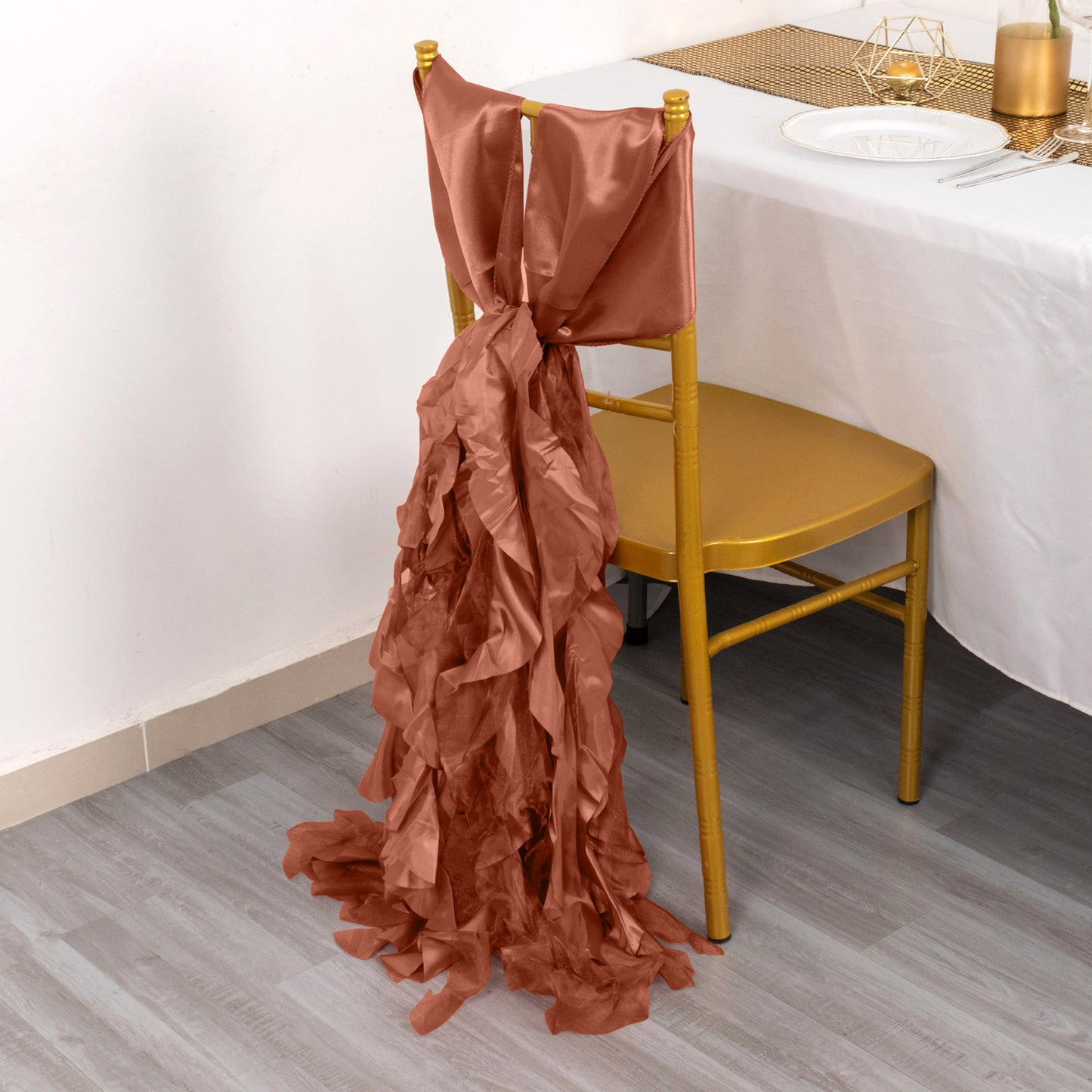 Terracotta curly willow chiffon satin chair sash on a gold chair.
