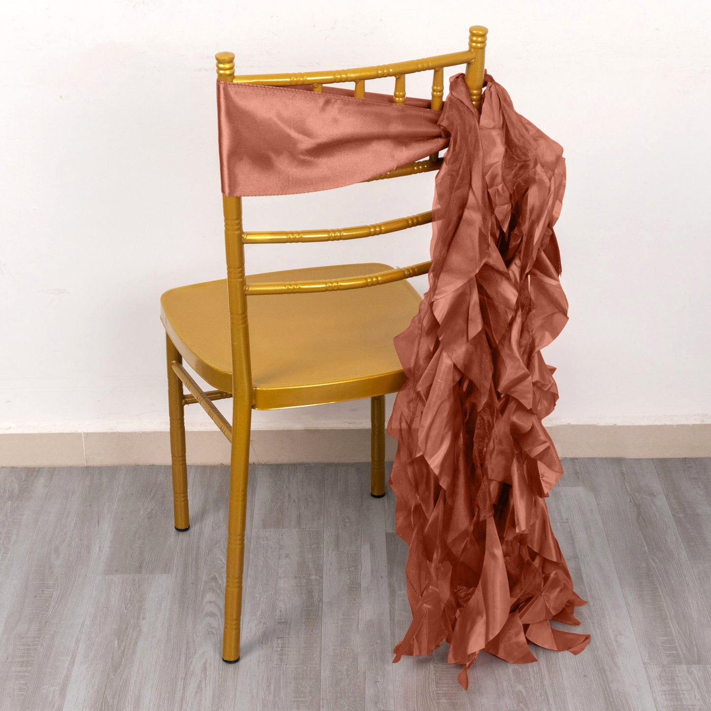 Terracotta curly willow chiffon satin chair sash on a gold chair.