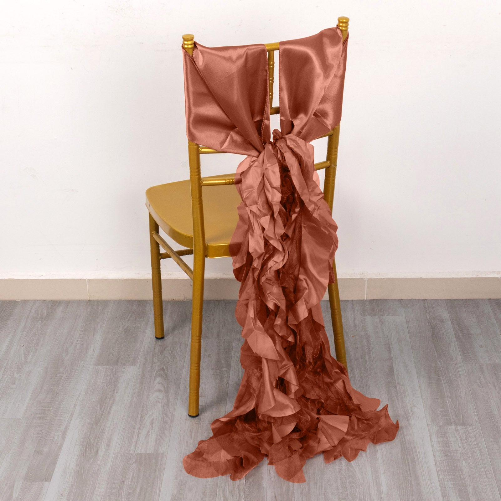 Terracotta curly willow chiffon satin chair sash on a gold chair.
