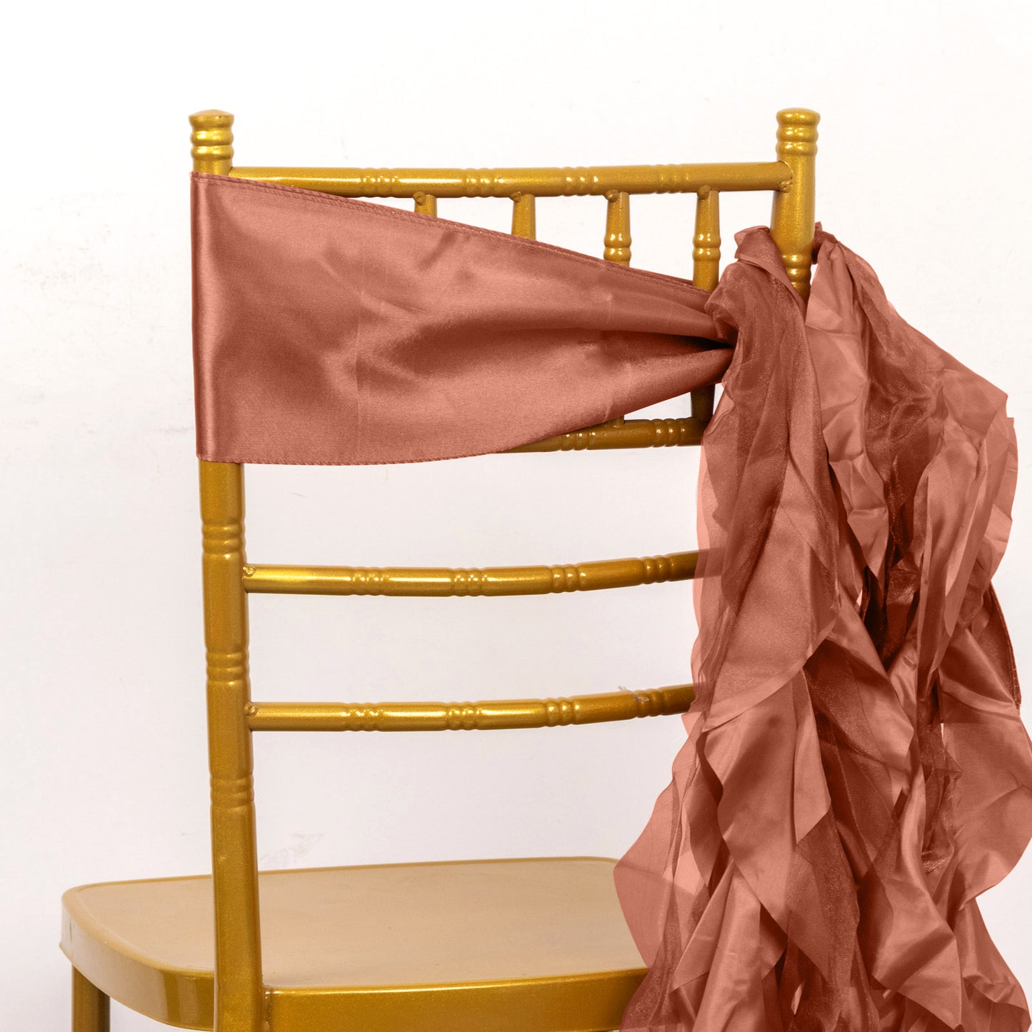 Terracotta curly willow chiffon satin chair sash on a gold chair.