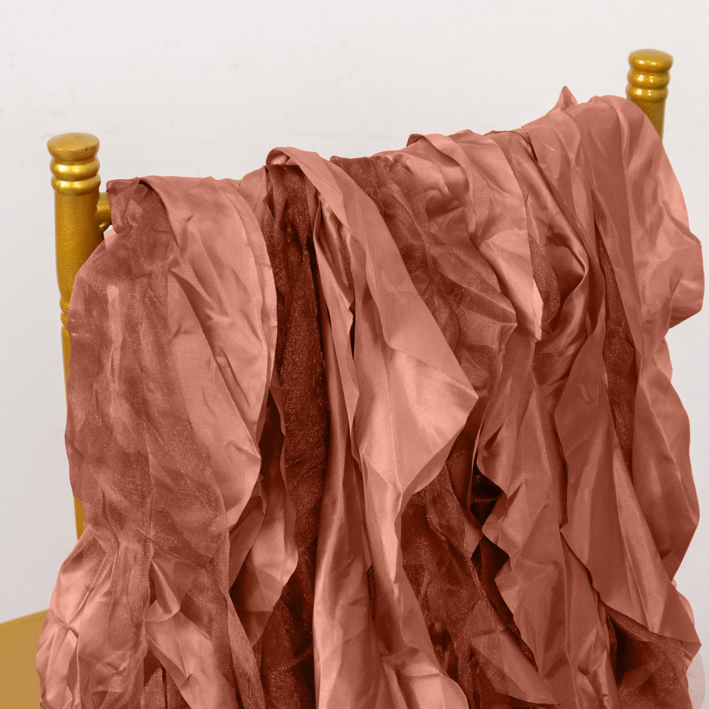 Terracotta curly willow chiffon satin chair sashes draped on a chair.