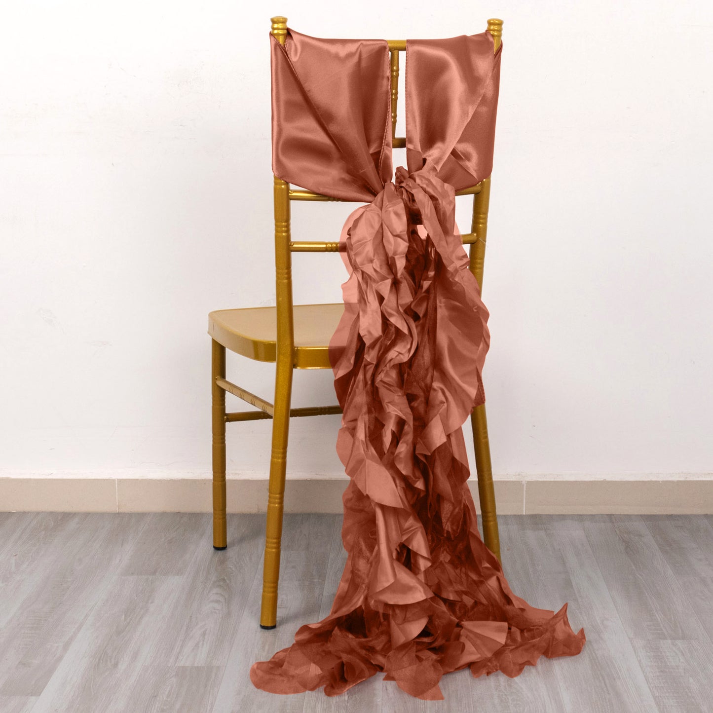 Terracotta curly willow chiffon satin chair sashes on a yellow chair.