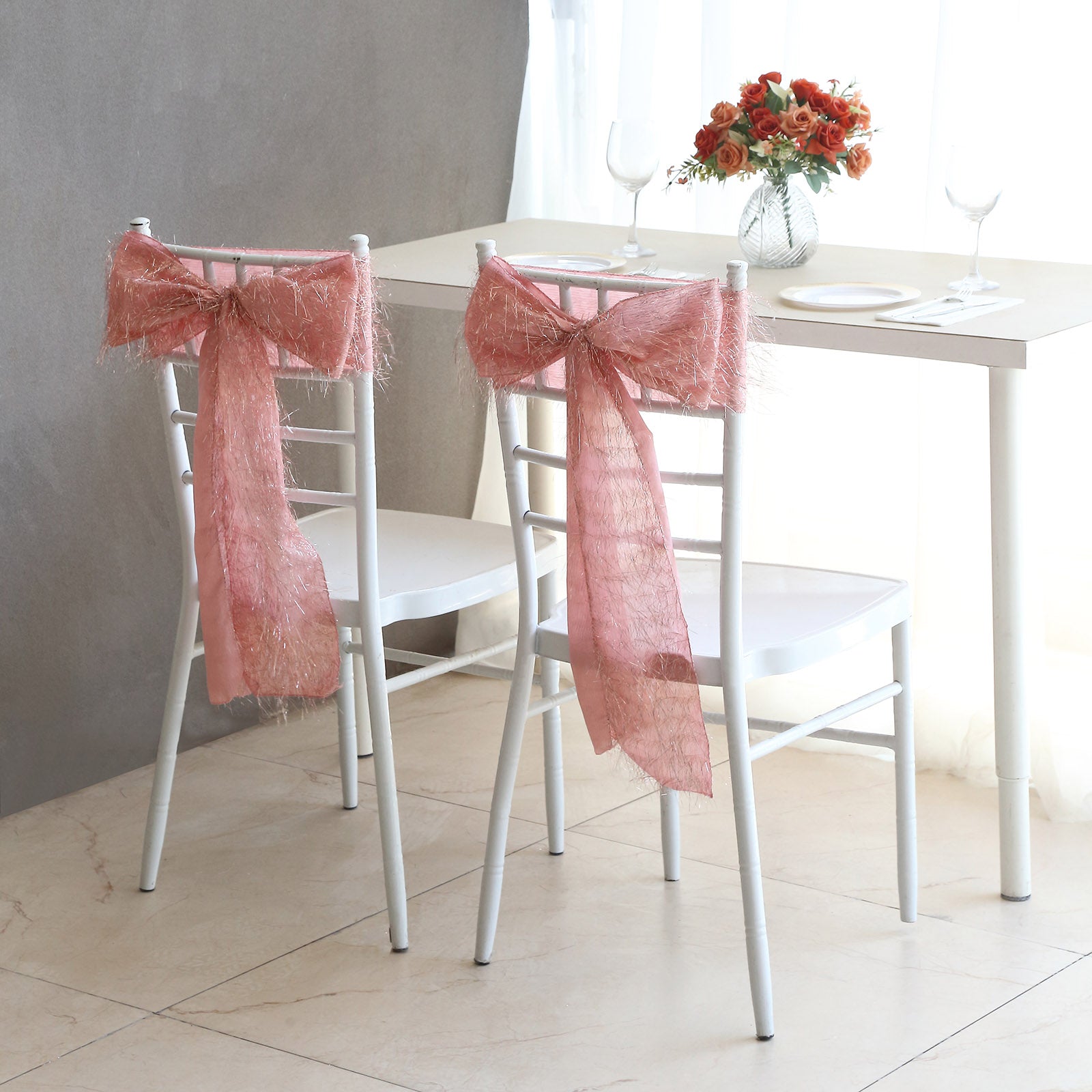 Rose gold metallic fringe tinsel chair sashes on white chairs.
