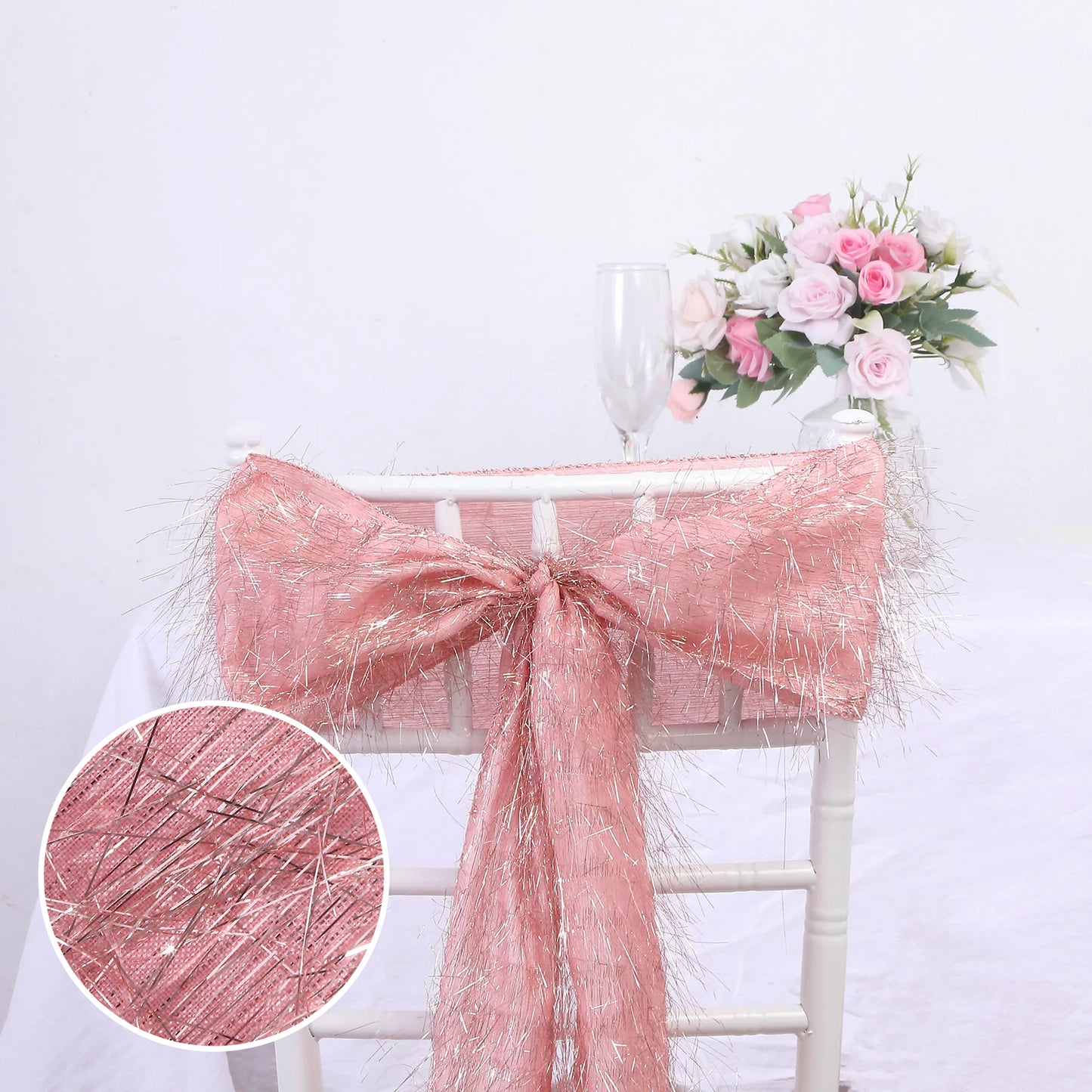 Rose gold metallic fringe tinsel chair sash on a white chair.