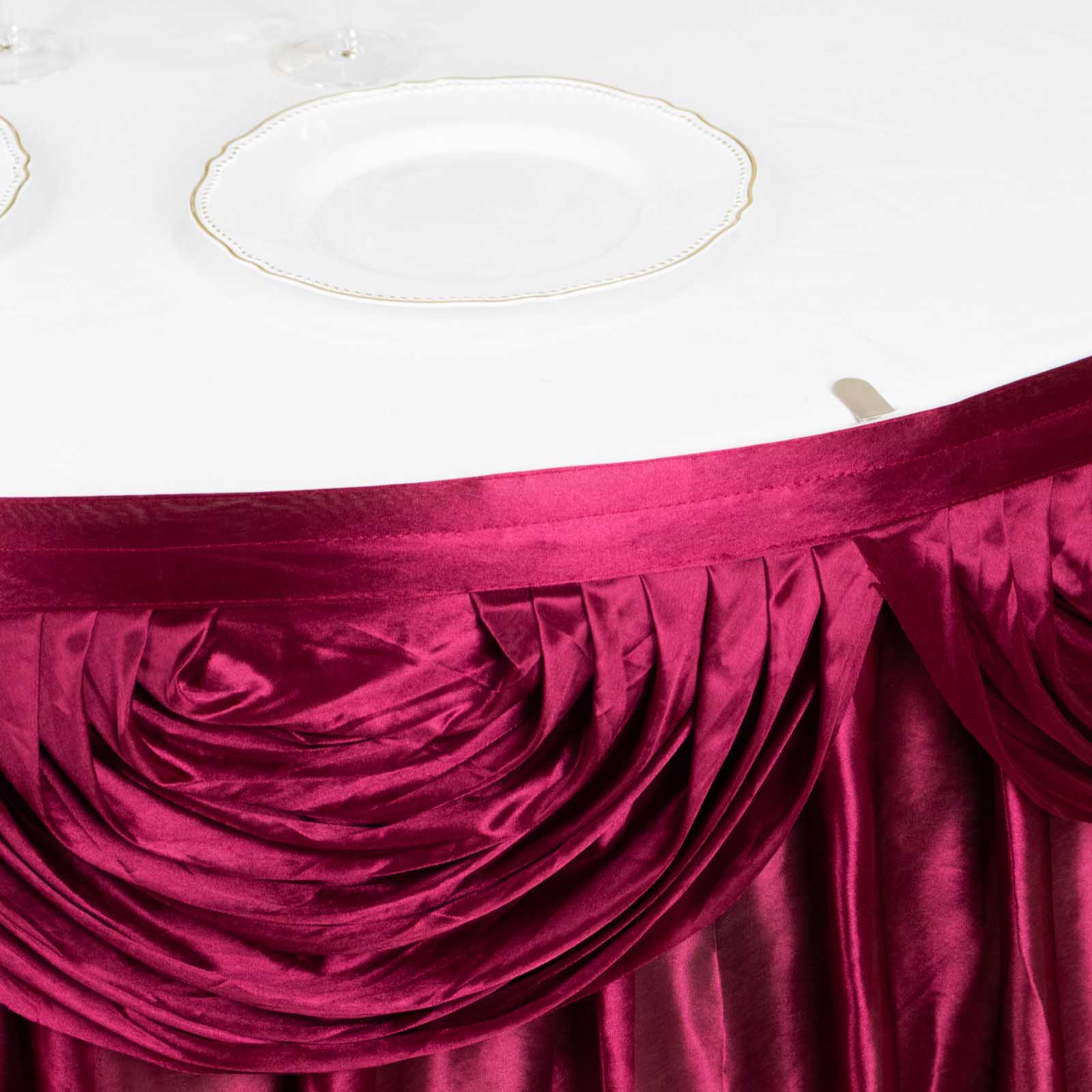 Burgundy pleated satin table skirt draped elegantly over a table.