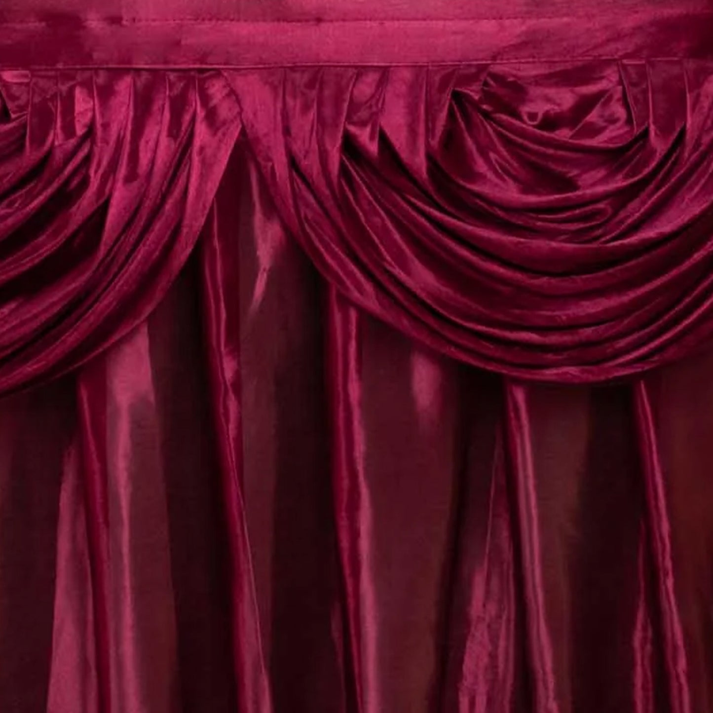 Burgundy pleated satin table skirt with double drape detailing. #whtbkgd