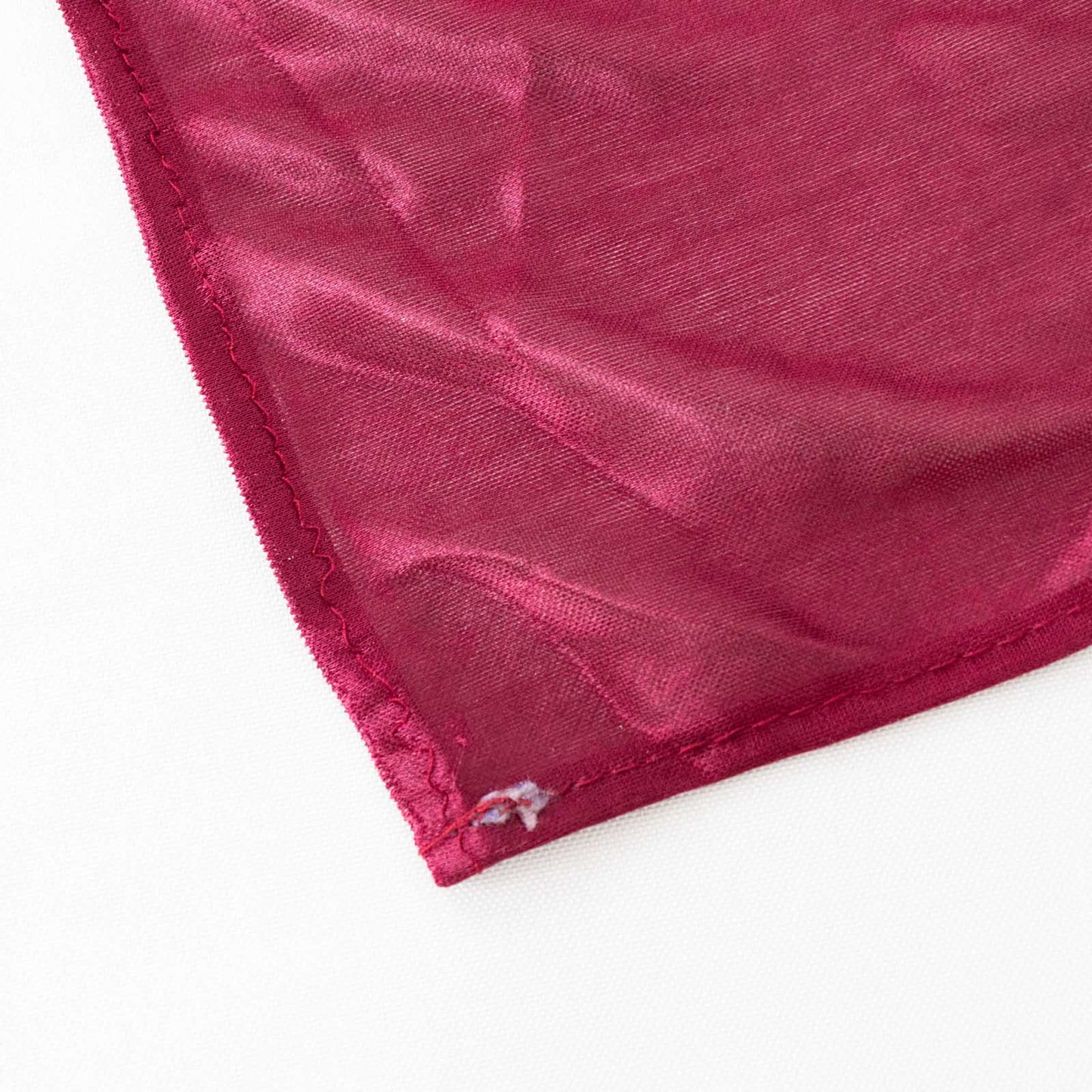 Burgundy pleated satin table skirt corner detail.