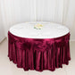 14ft burgundy pleated satin double drape table skirt on a round table.
