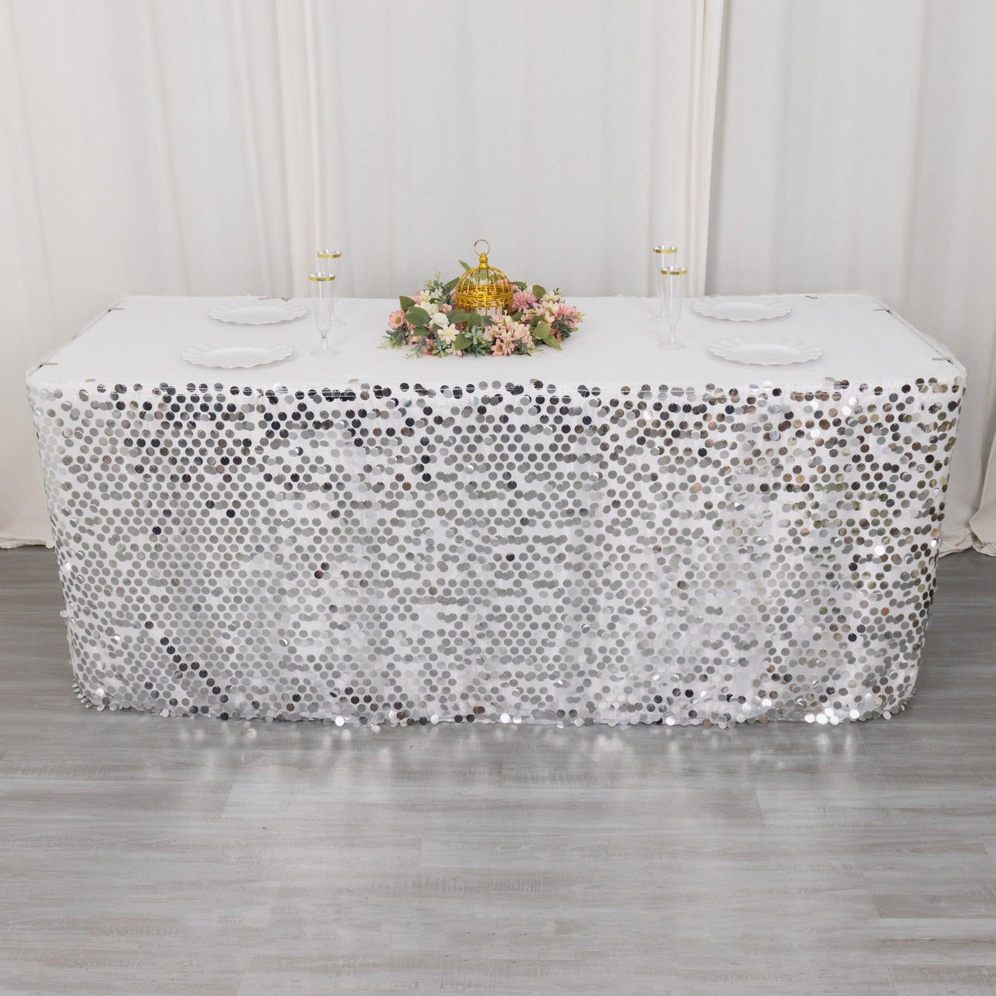 Silver sequin table skirt for elegant events and celebrations.