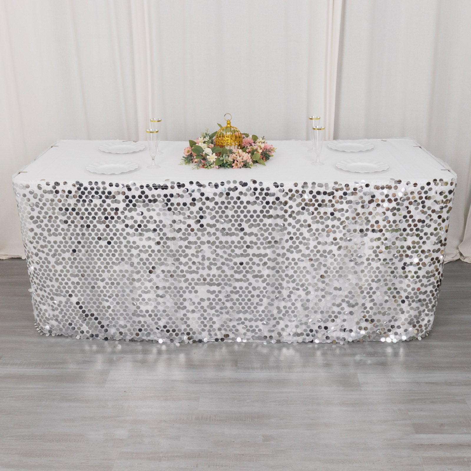 Silver sequin table skirt for elegant events and celebrations.