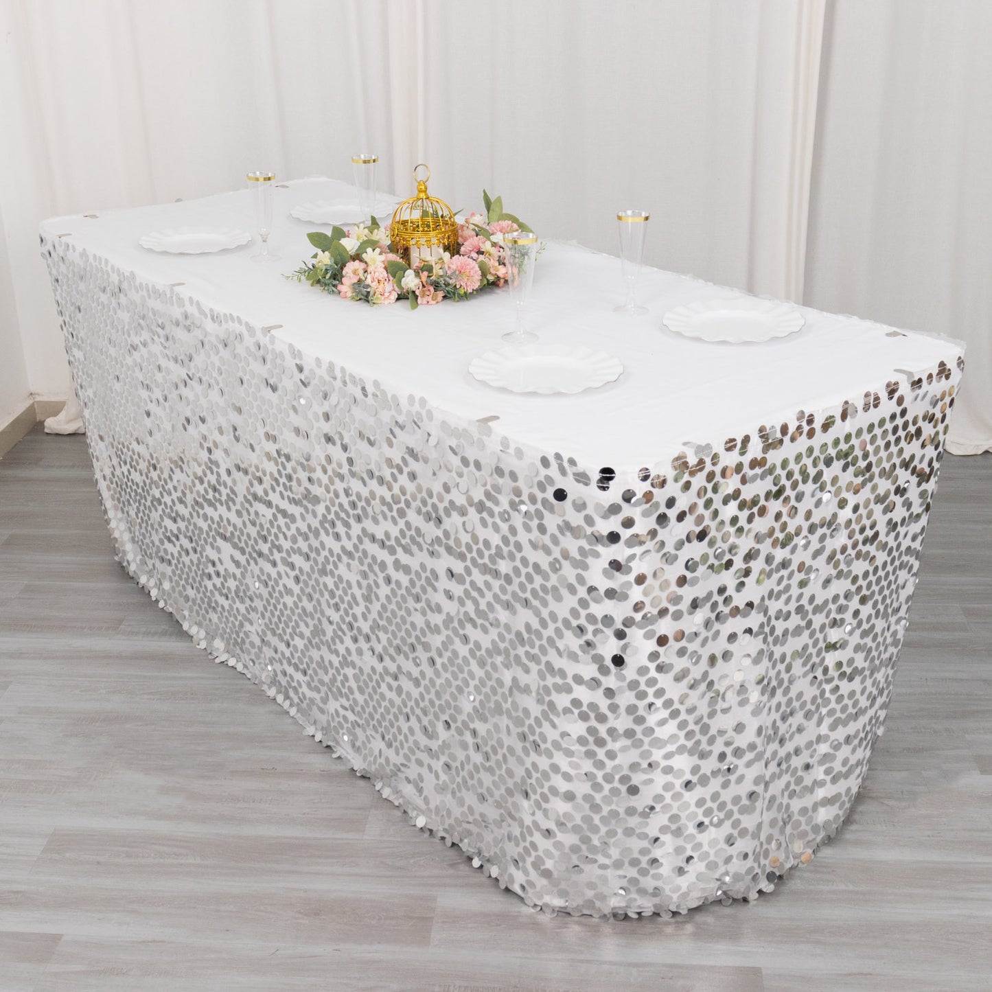 21ft silver sequin table skirt on a dining table with floral centerpiece.
