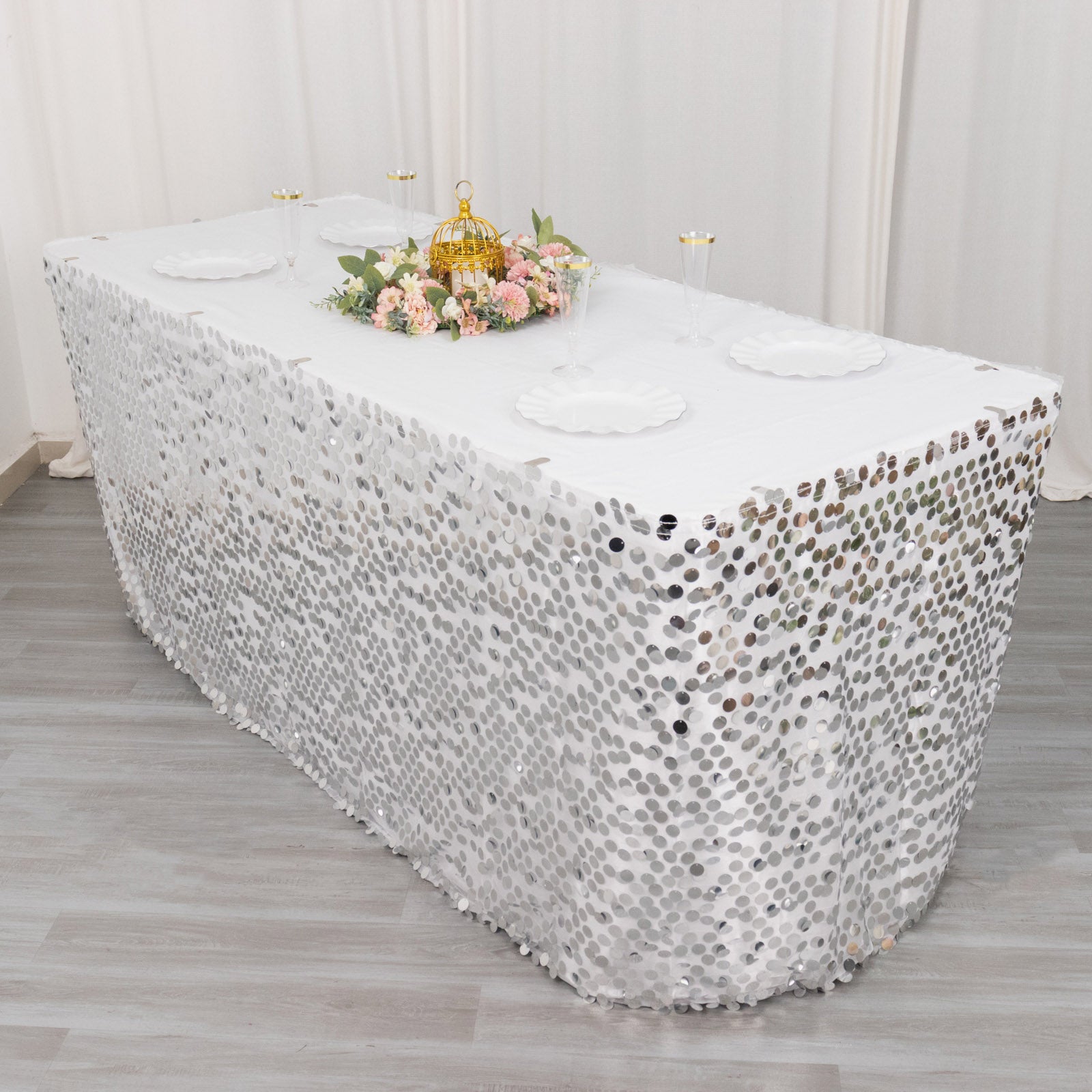 21ft silver sequin table skirt on a dining table with floral centerpiece.