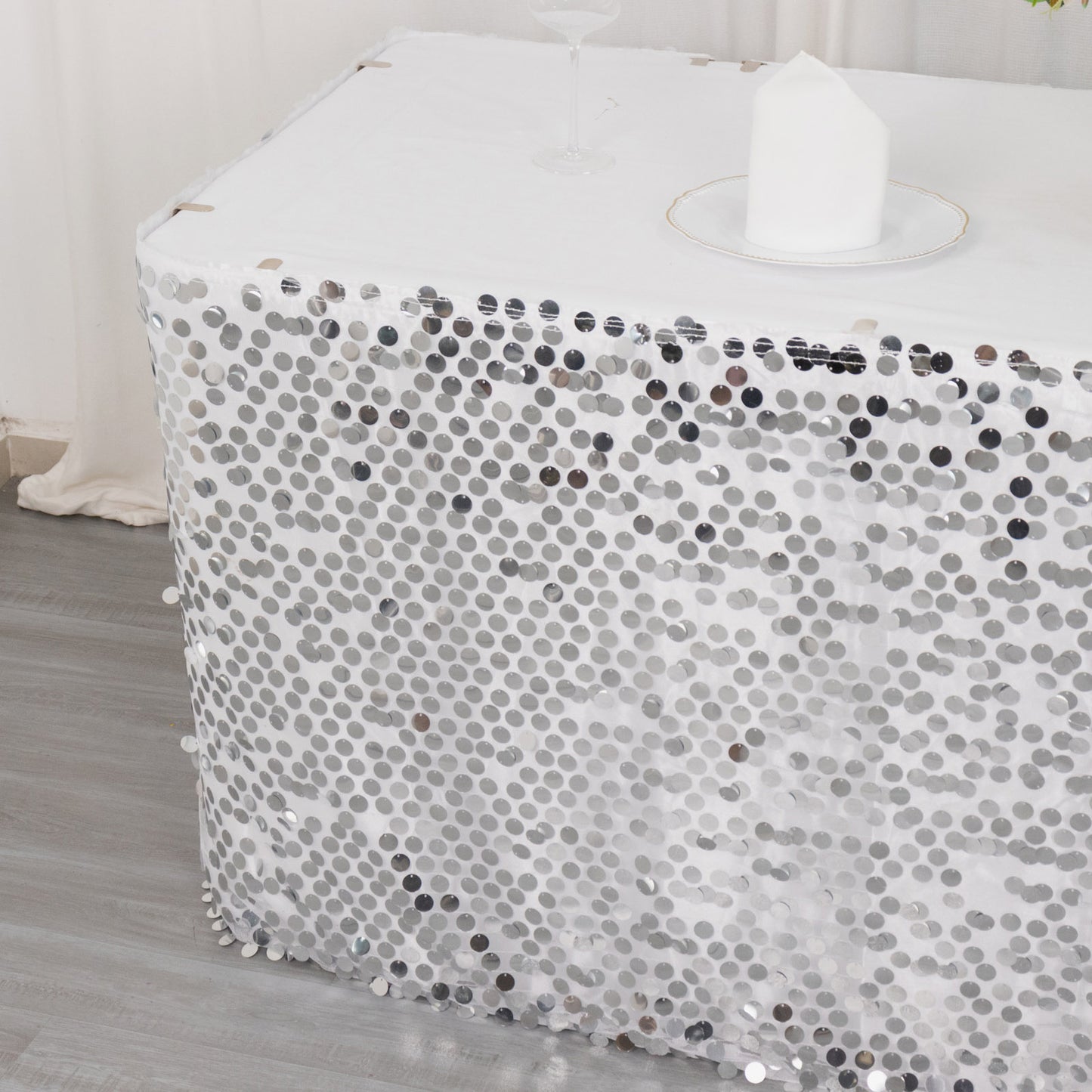 Silver dual layered satin table skirt with sequins.