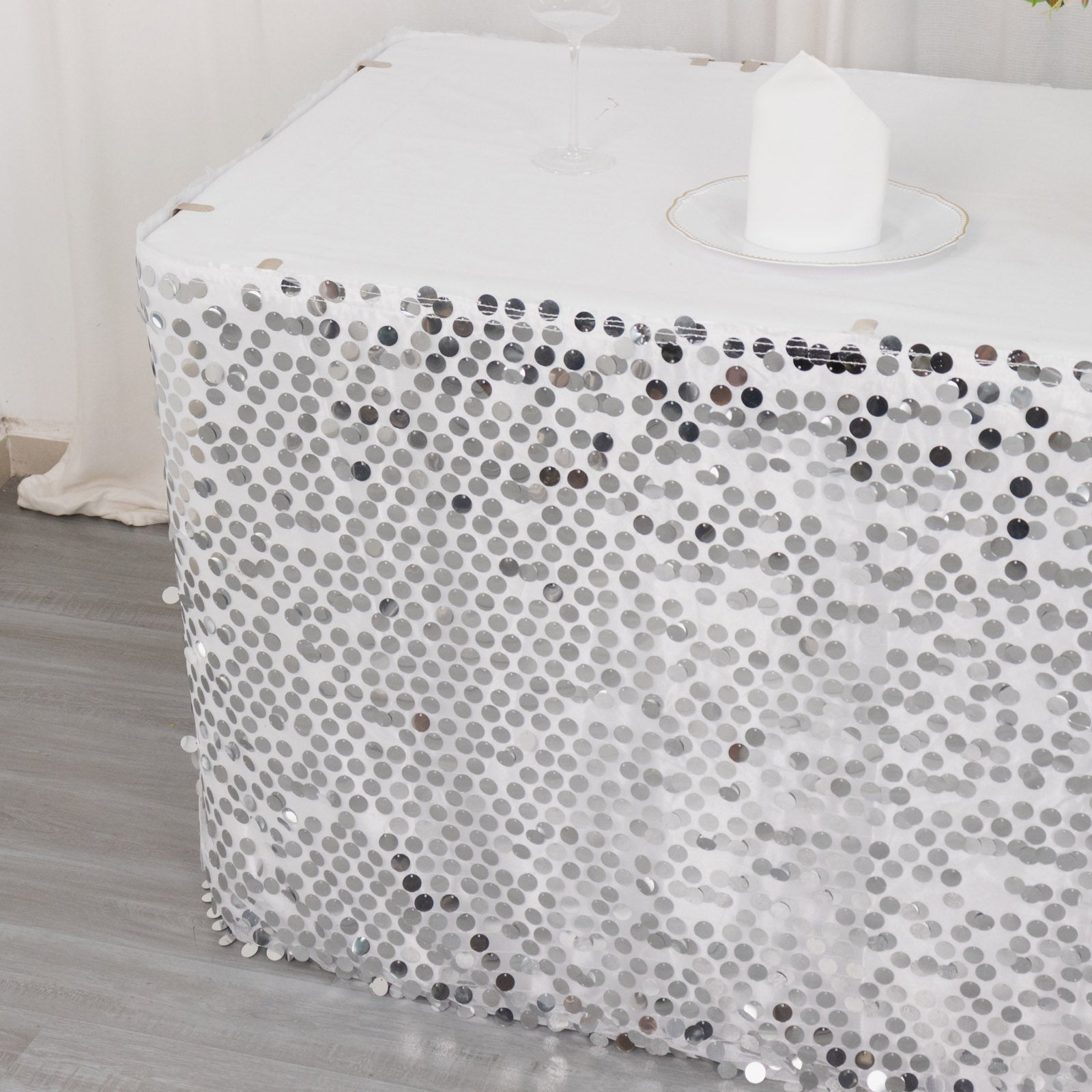 Silver dual layered satin table skirt with sequins.