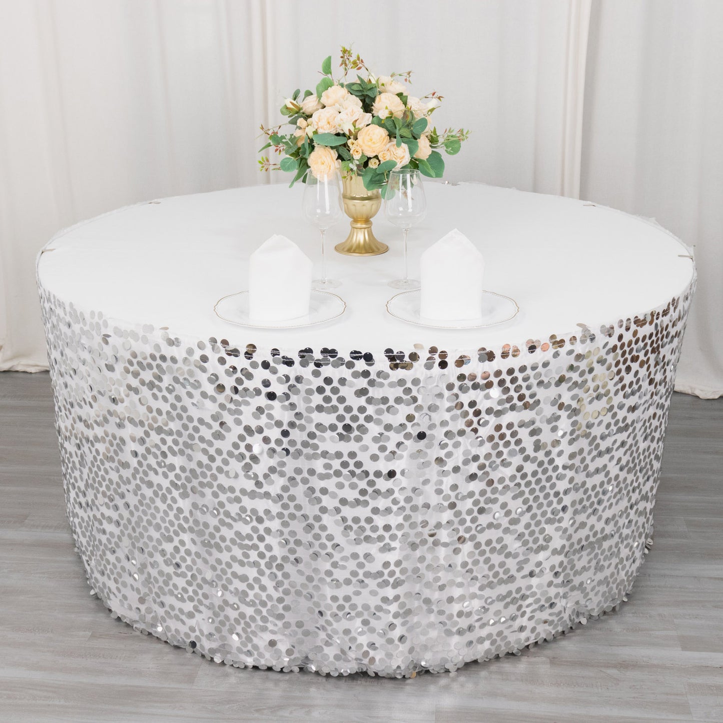 Silver sequin table skirt with dual layers on a round table.
