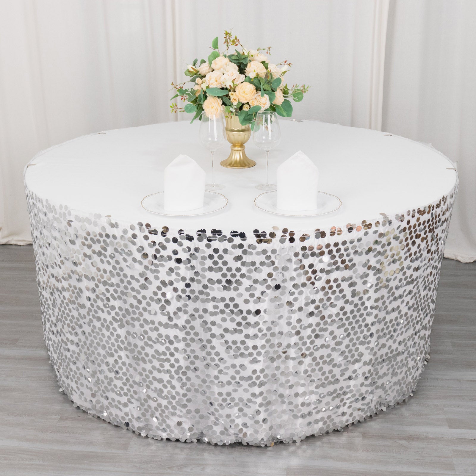 Silver sequin table skirt with dual layers on a round table.