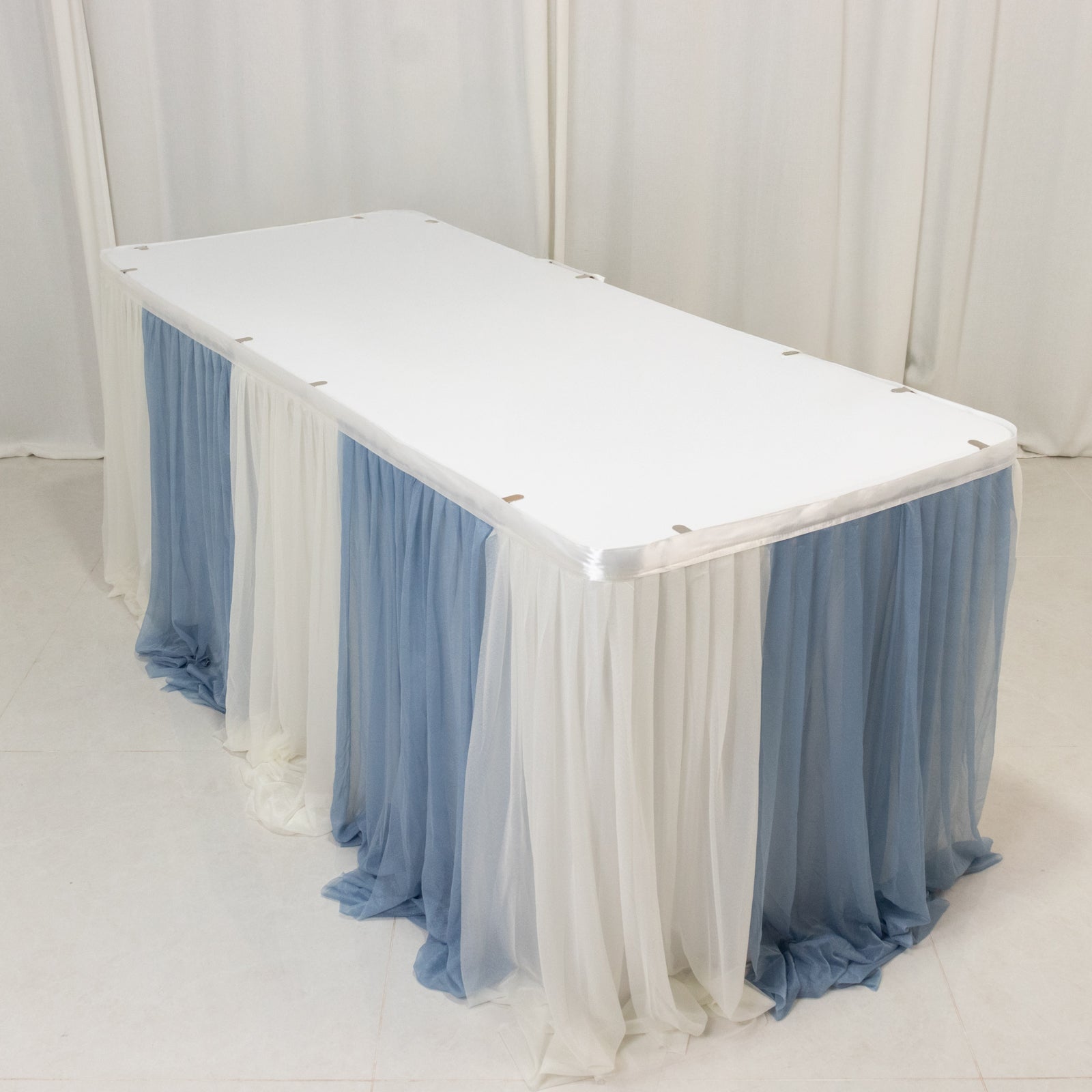 Dusty Blue table skirt draping elegantly over a white table.
