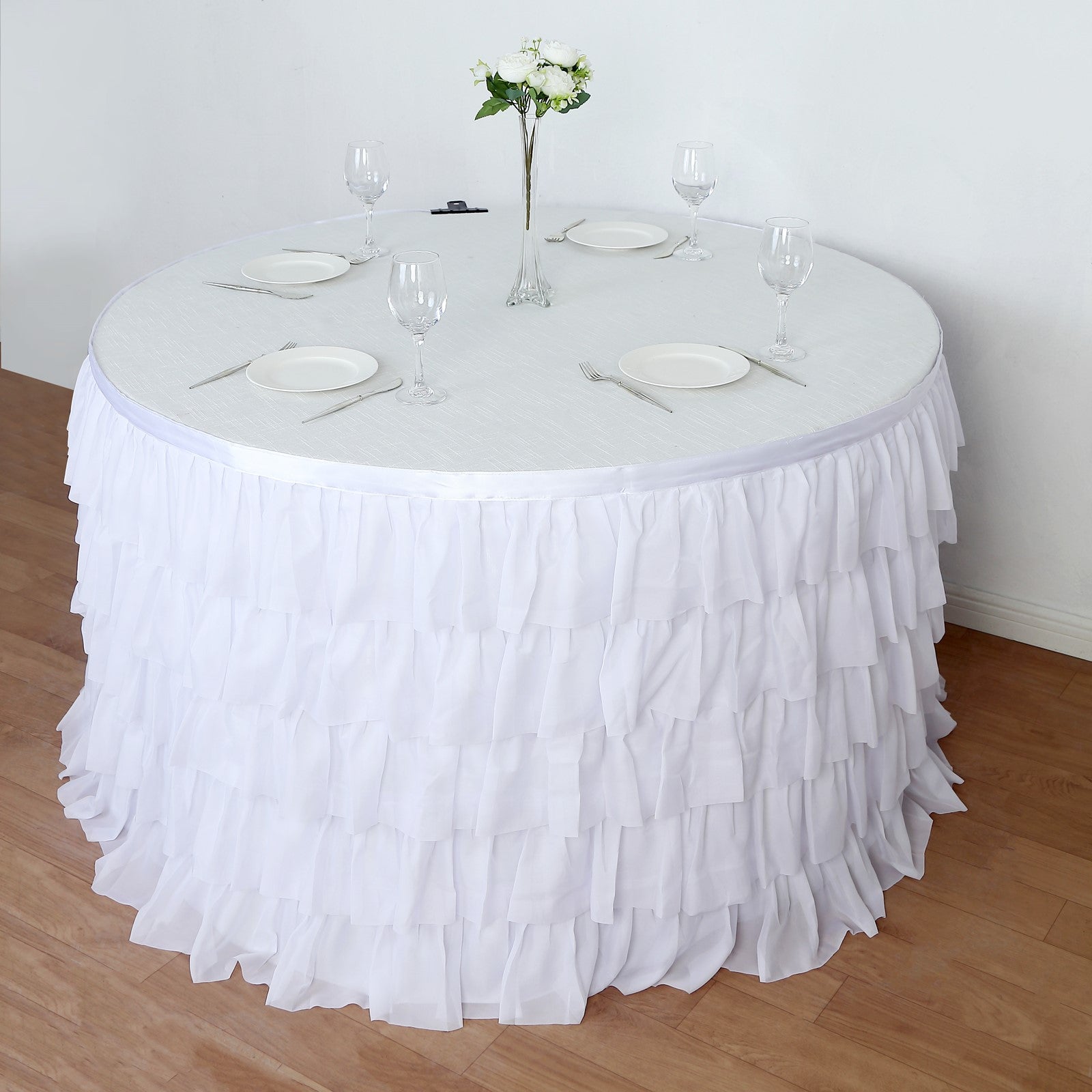 Elegant white ruffled tablecloth on a round table for events and celebrations.