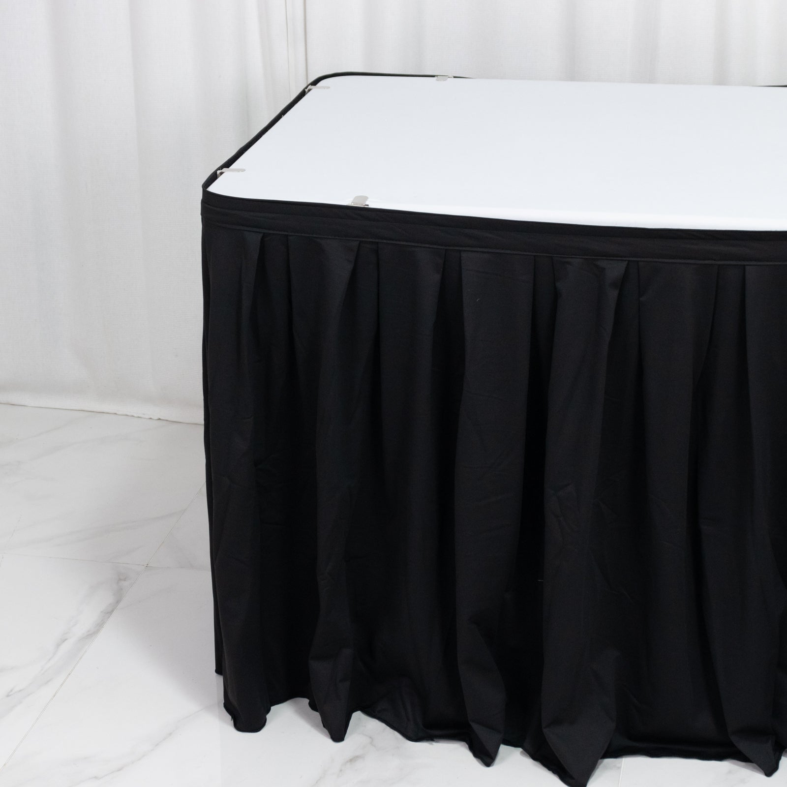 Black 17ft wrinkle-free and stain-resistant scuba table skirt for events.