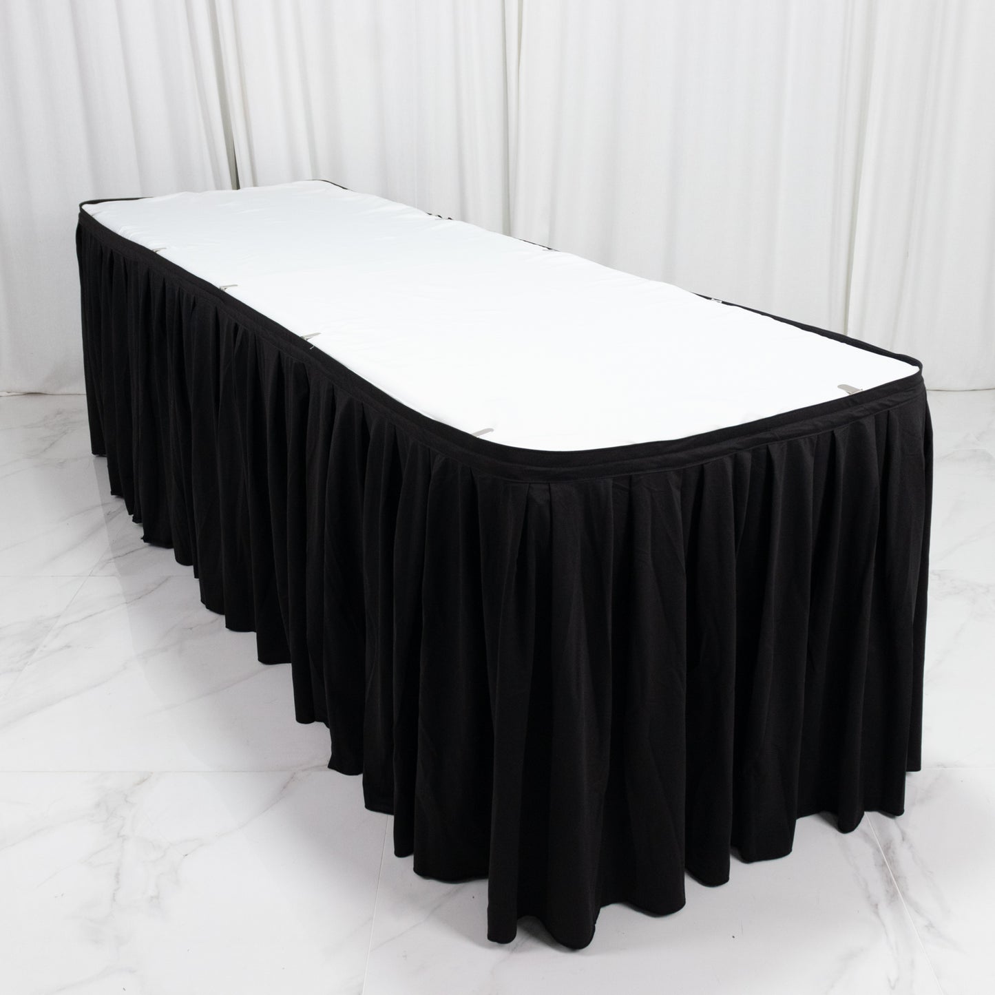 Black 21ft wrinkle-free and stain-resistant table skirt for events.