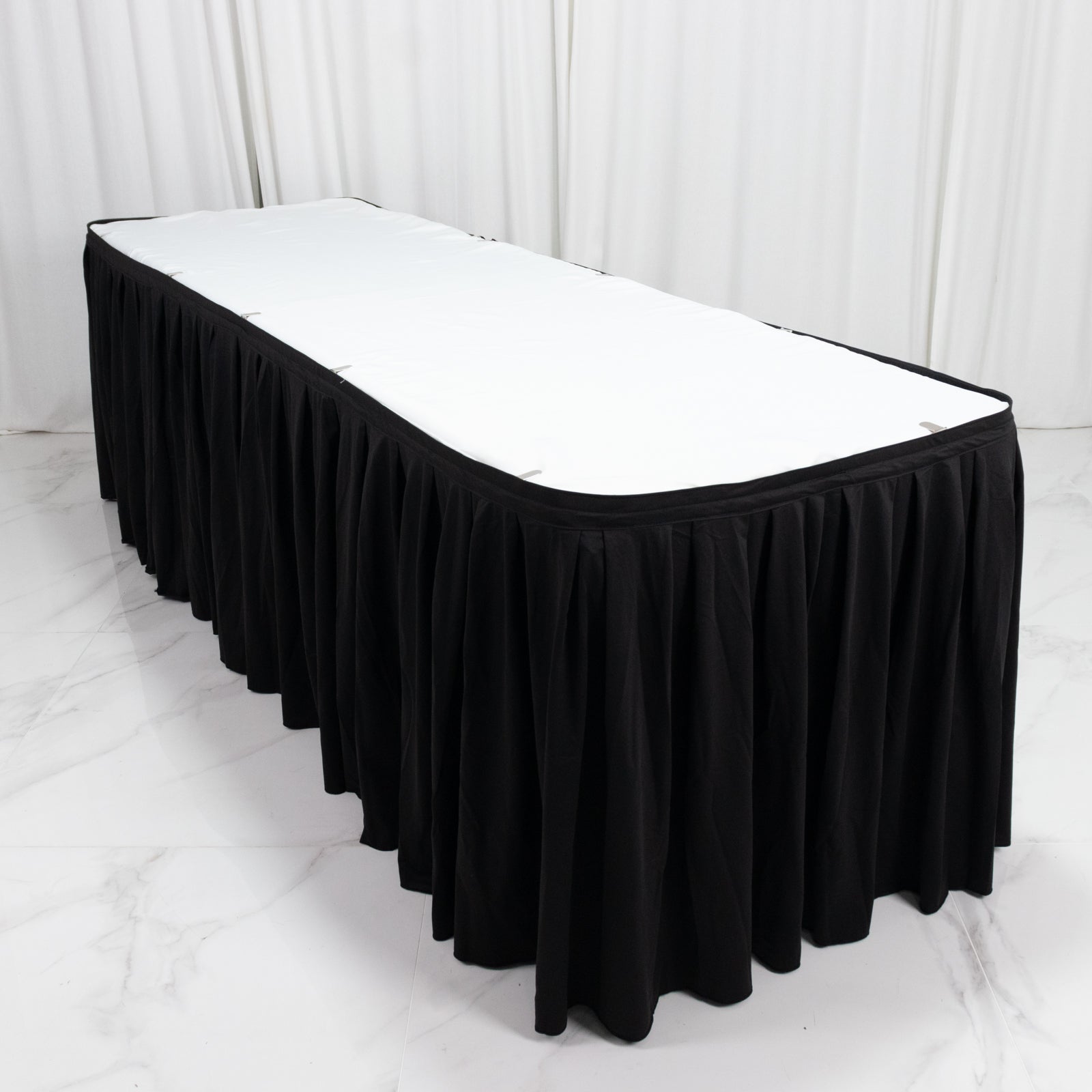 Black 21ft wrinkle-free and stain-resistant table skirt for events.