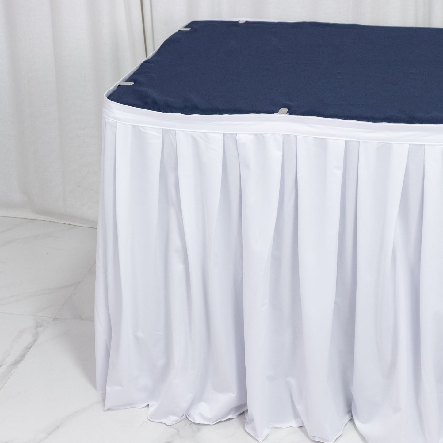 White 14ft scuba table skirt with shirred pleat, wrinkle-free and stain-resistant.