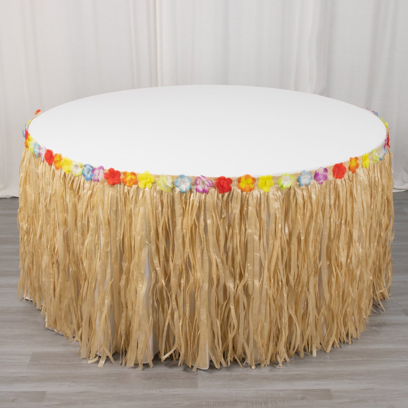 Natural raffia grass table skirt for Hawaiian themed party decorations.