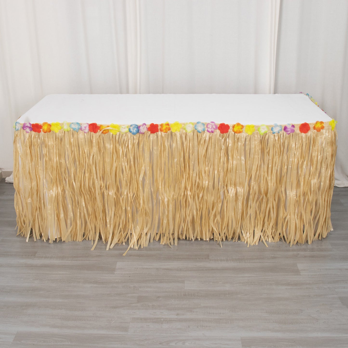 Natural raffia grass table skirt for Hawaiian luau party decorations.