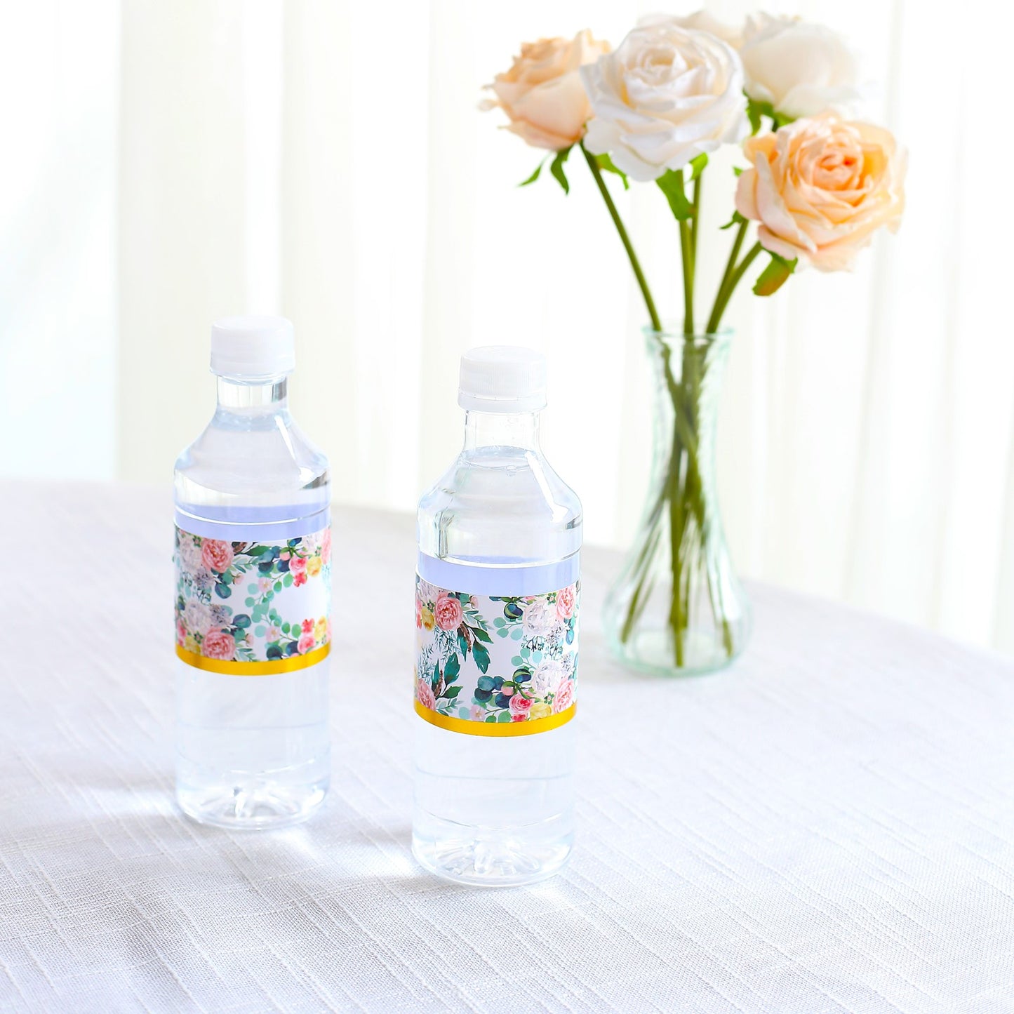 White and pink water bottle labels with floral design and gold trim.