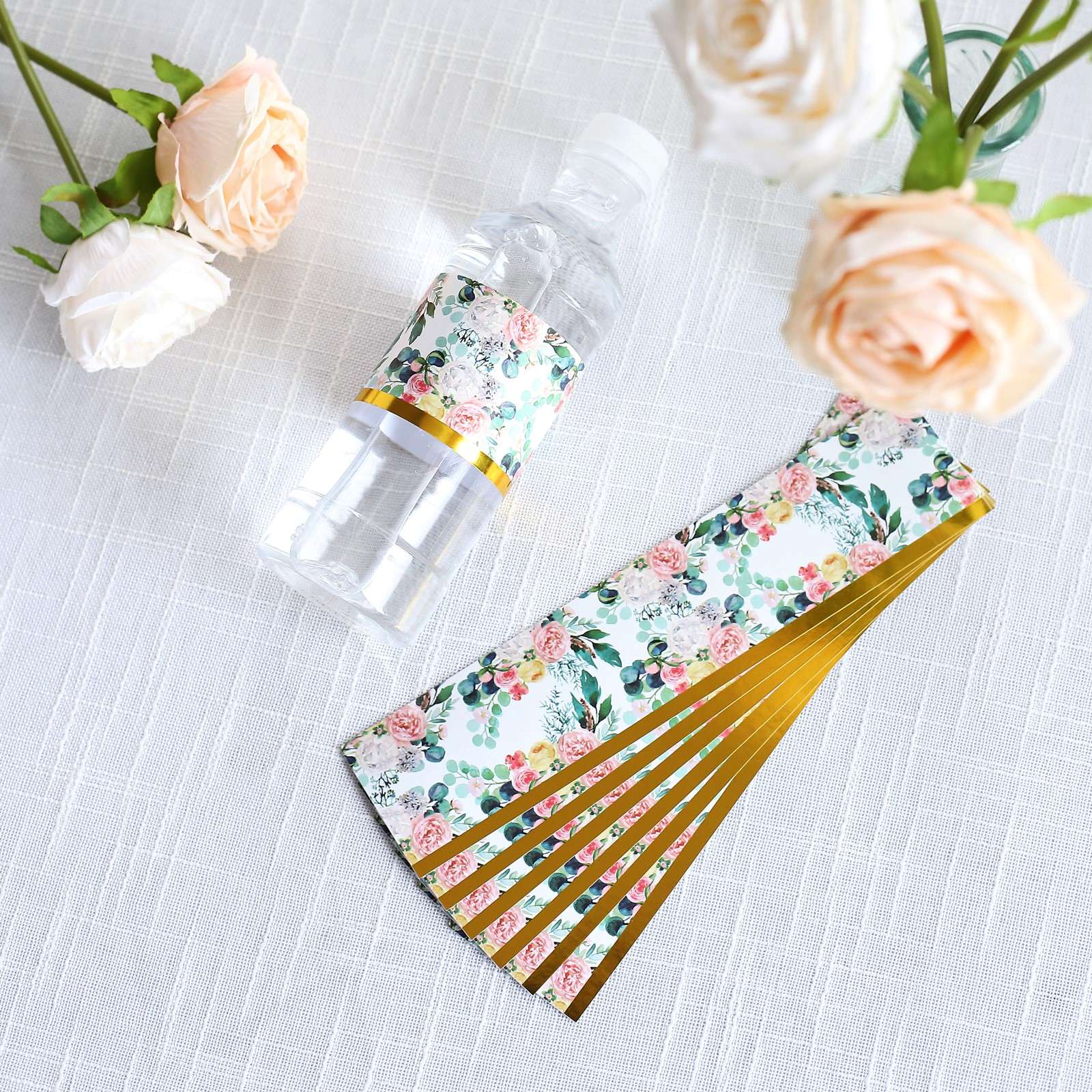 White and pink water bottle labels with floral design and gold trim.