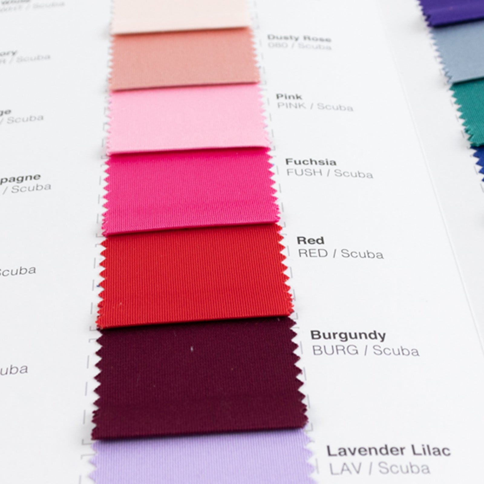 Fuchsia and red swatches from a scuba polyester fabric sample book.