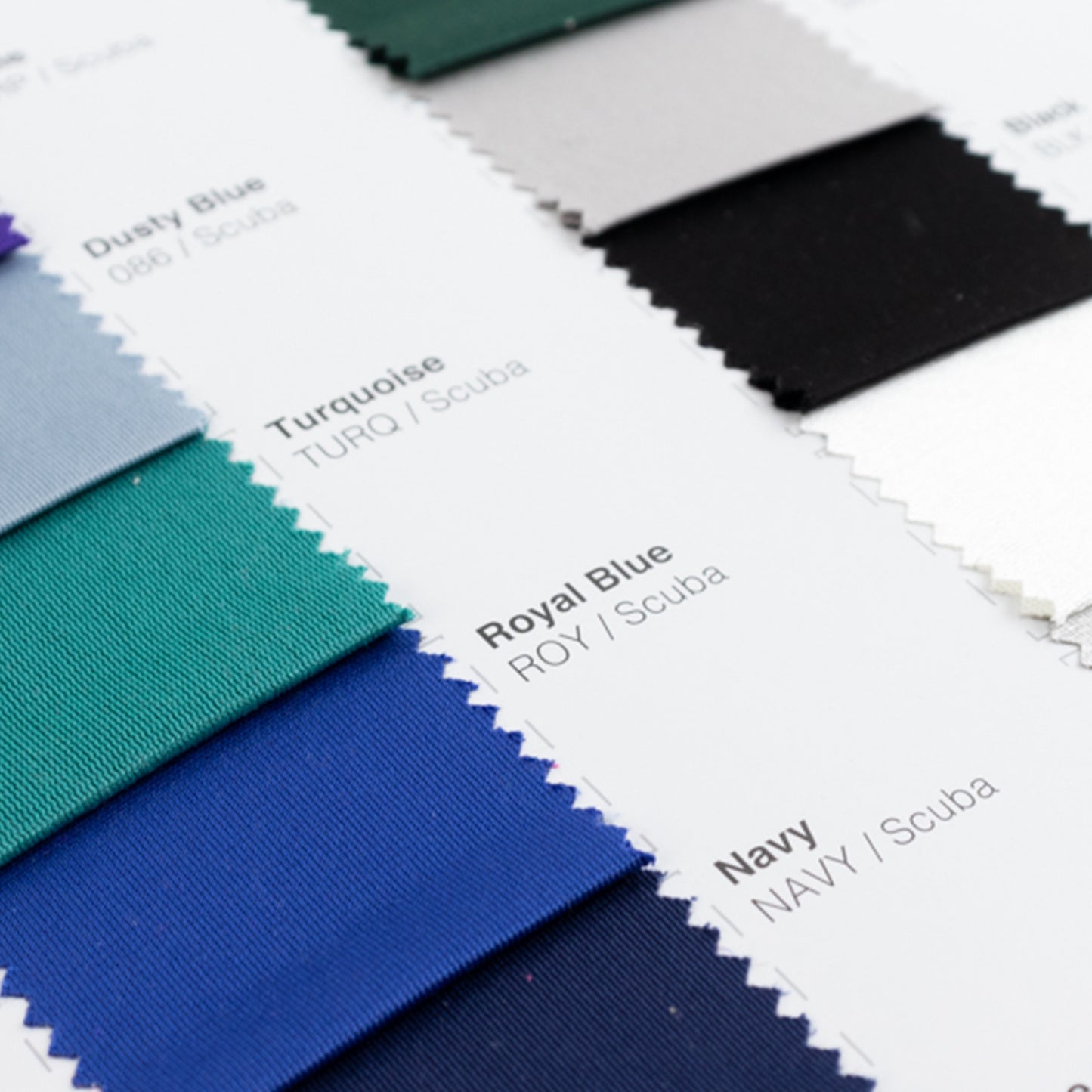 Royal blue and navy fabric swatches from a scuba polyester sample book.
