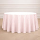 Blush round tablecloth on a wooden floor.