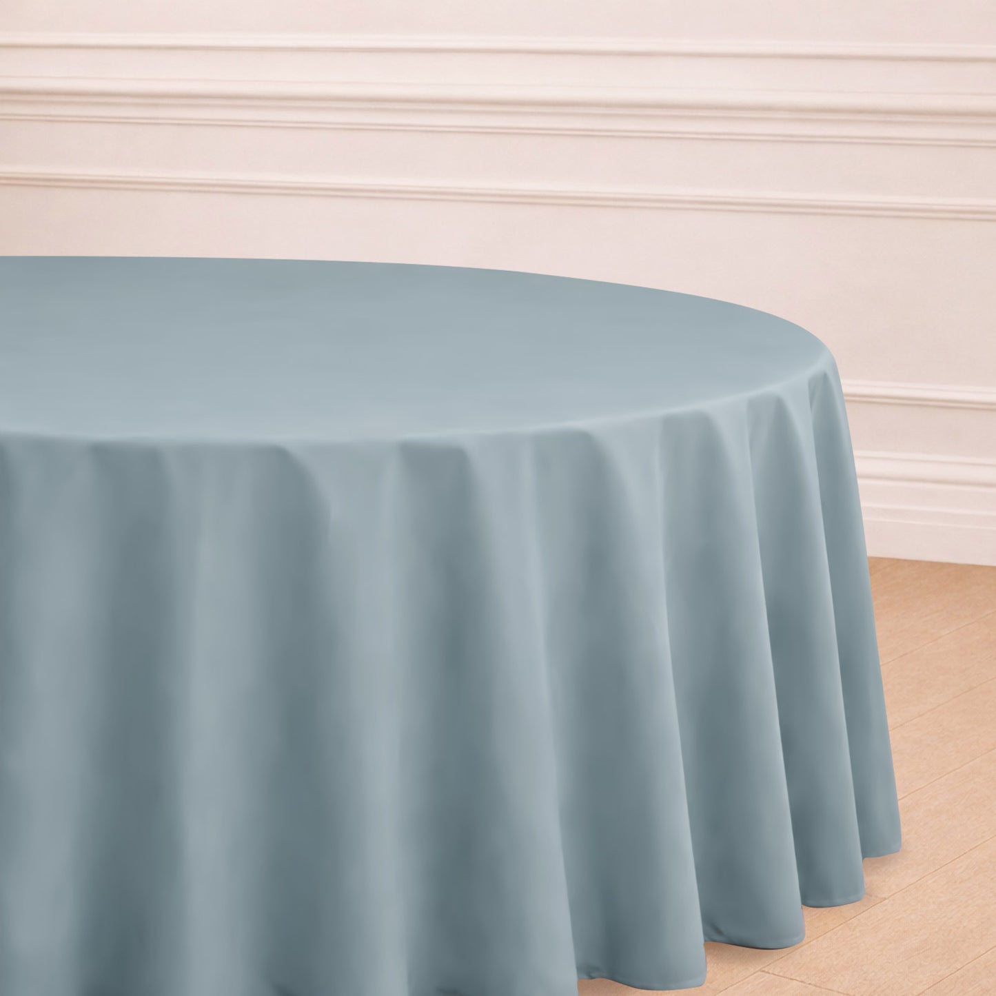 Dusty blue seamless polyester round tablecloth on a wooden floor.
