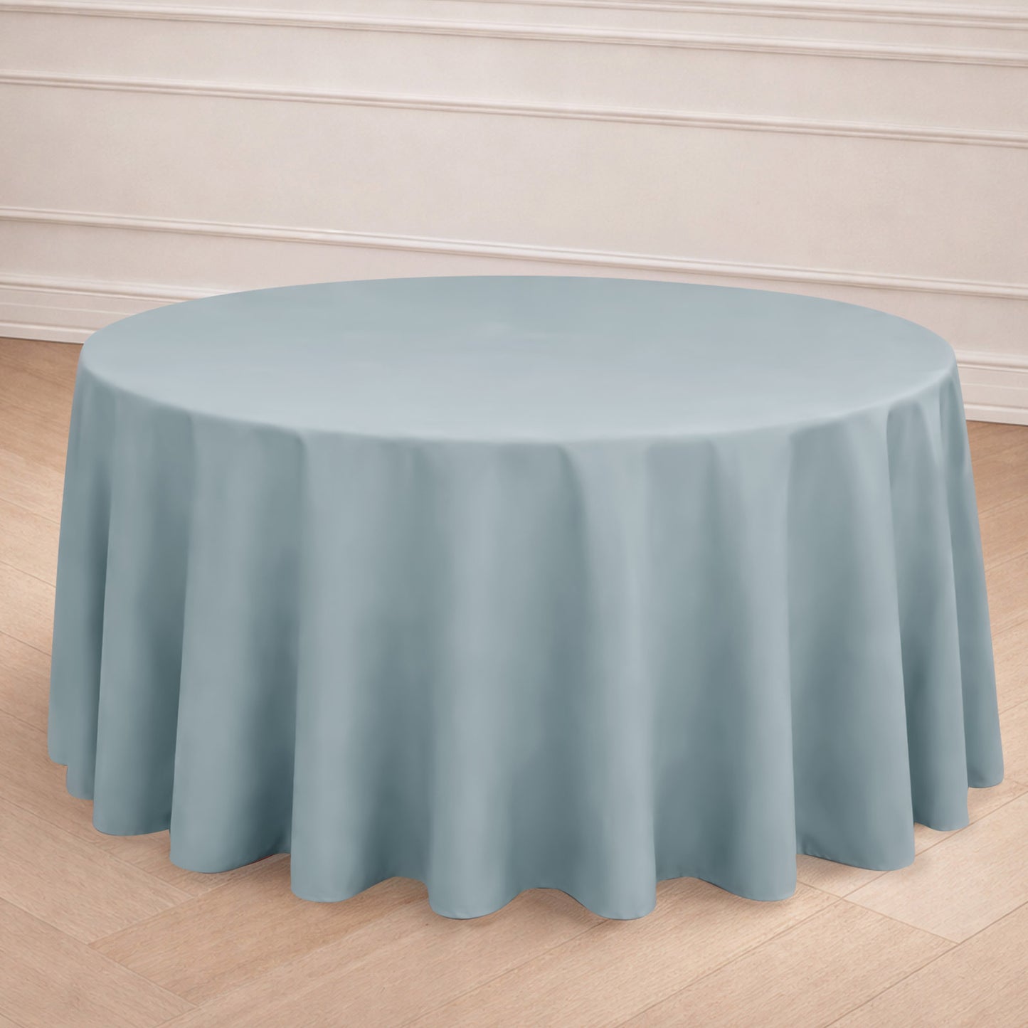 Dusty blue seamless round tablecloth on a wooden floor.