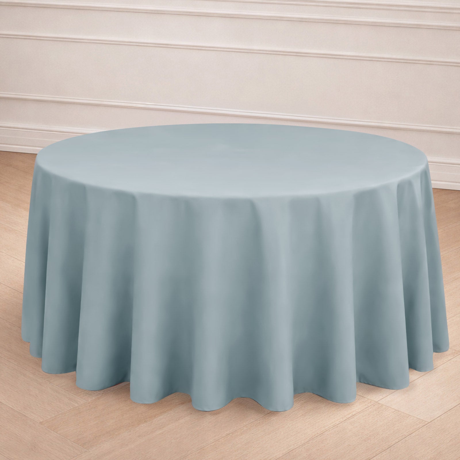 Dusty blue seamless round tablecloth on a wooden floor.