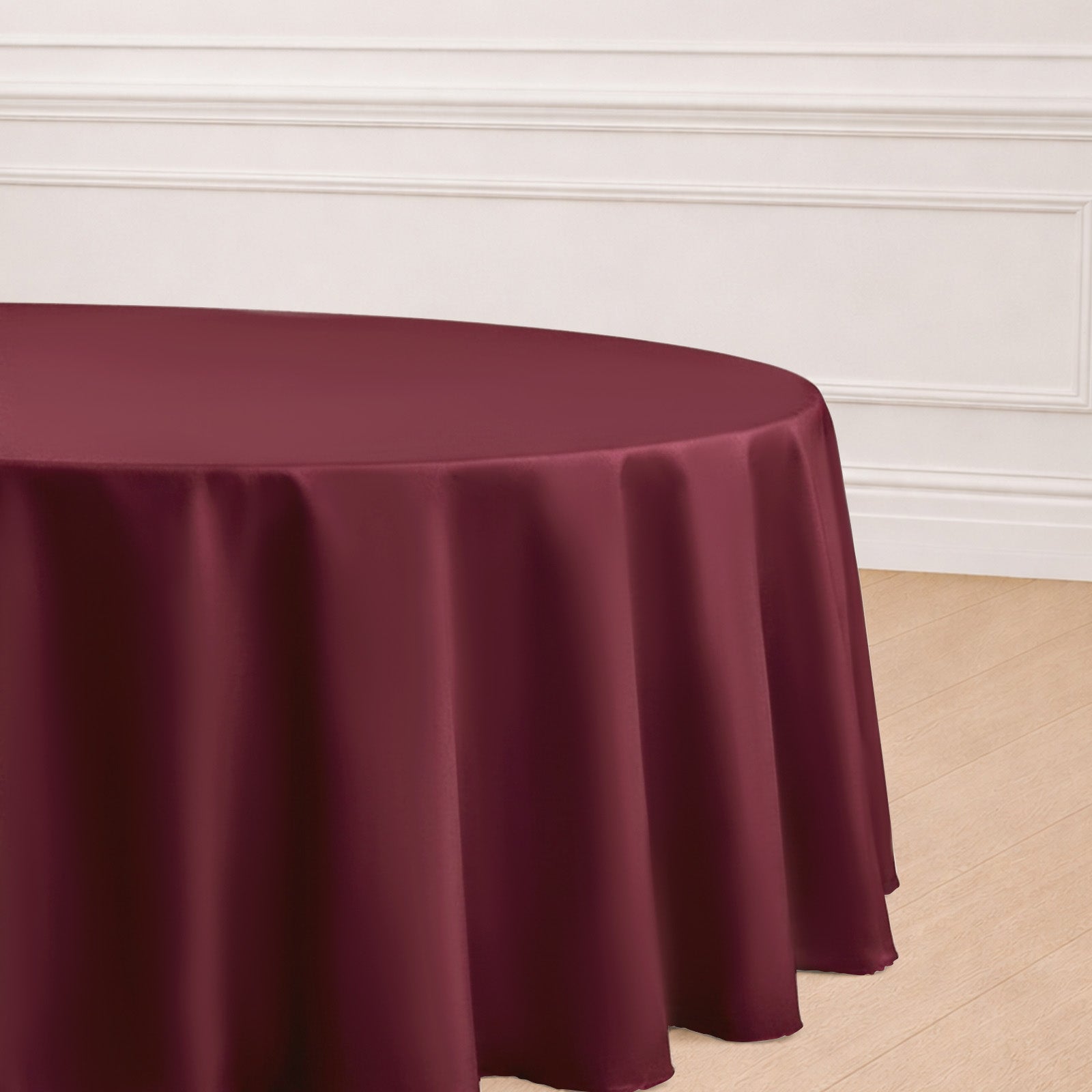 Burgundy seamless polyester round tablecloth on a wooden floor.