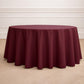 Burgundy seamless polyester round tablecloth on a wooden floor.